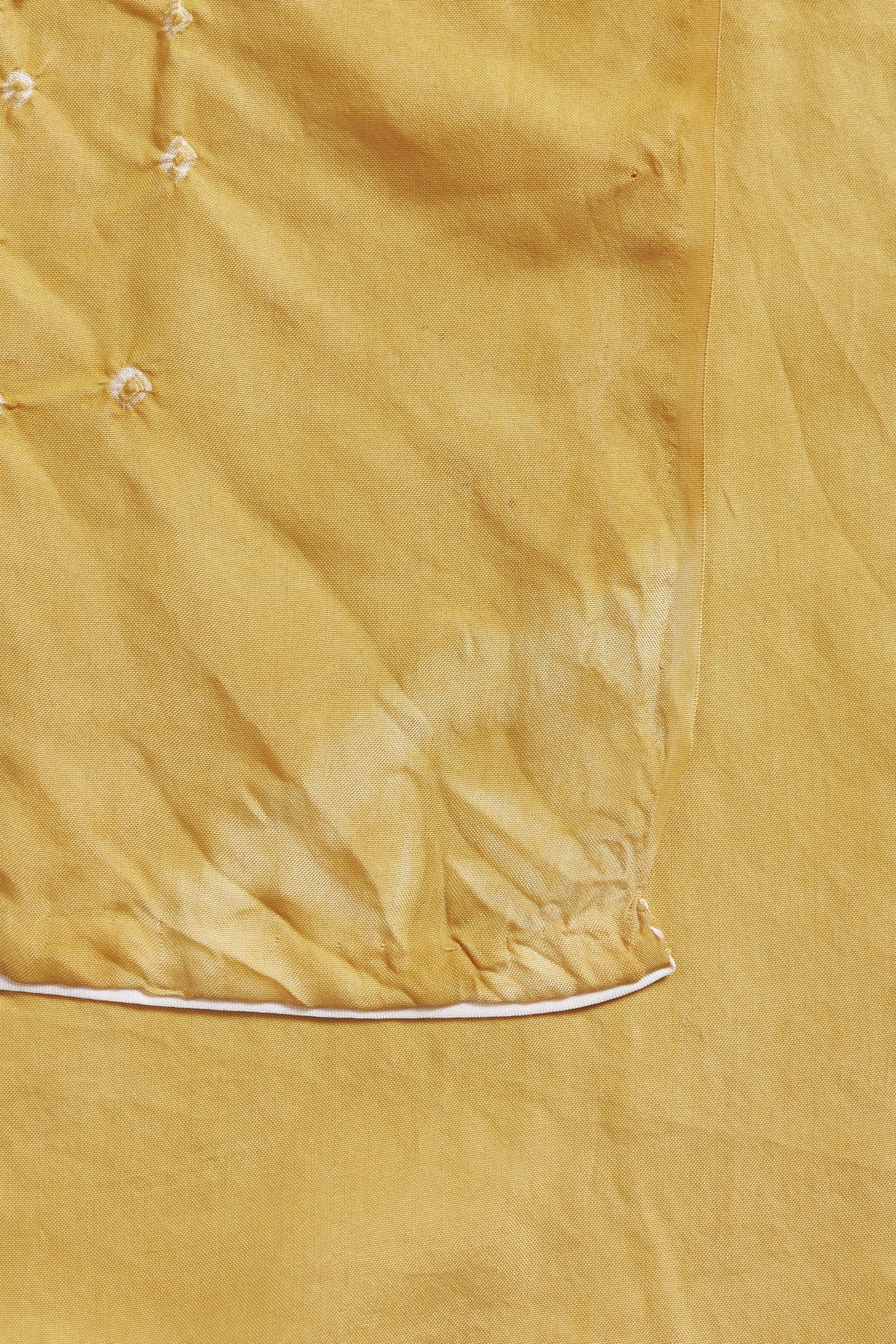 Close-up of a mustard yellow fabric with a subtle pattern