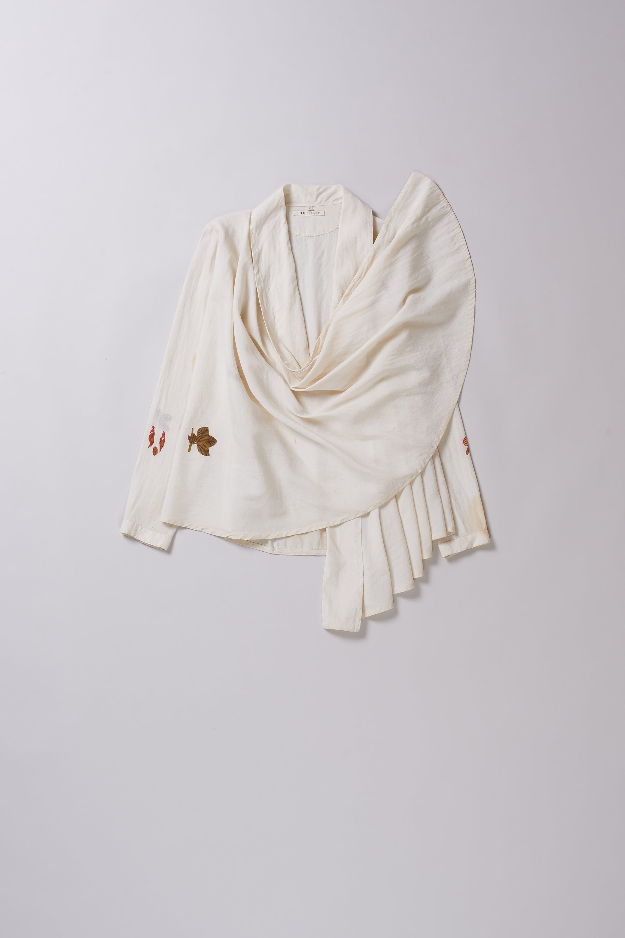 White scarf with fringe details on a light gray background