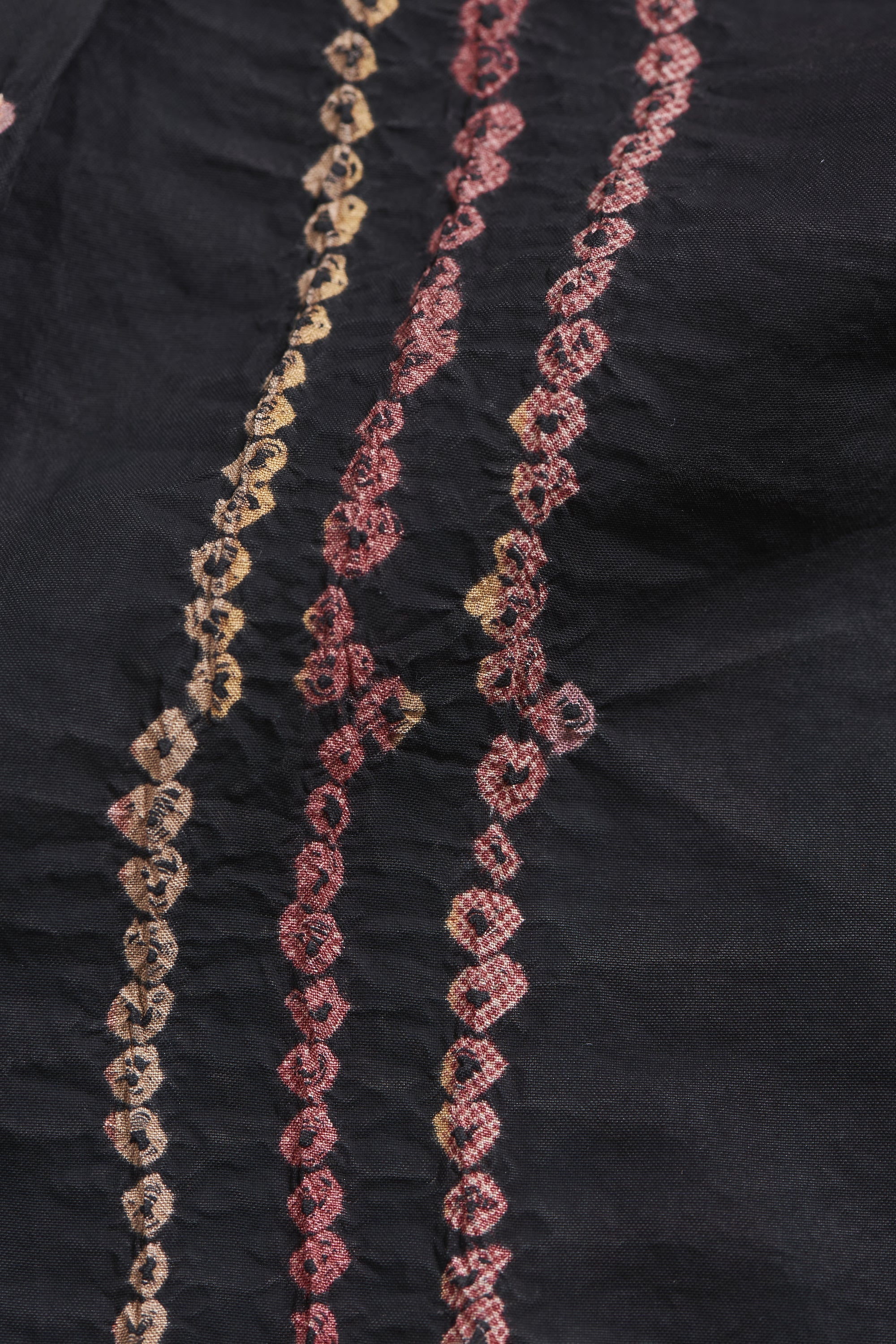 Decorative chain with pink and gold patterns on a black background