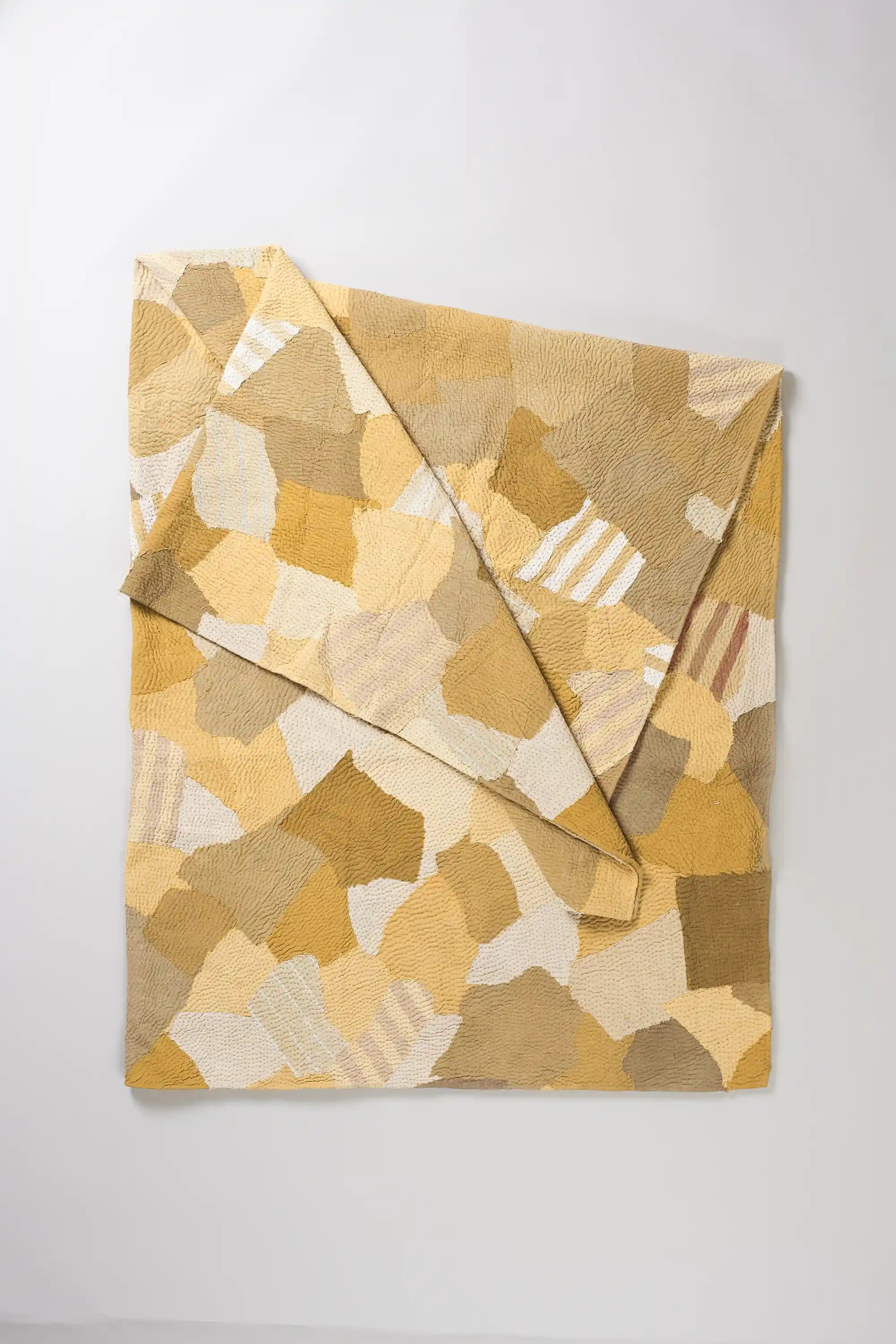 Folded quilt on light grey background