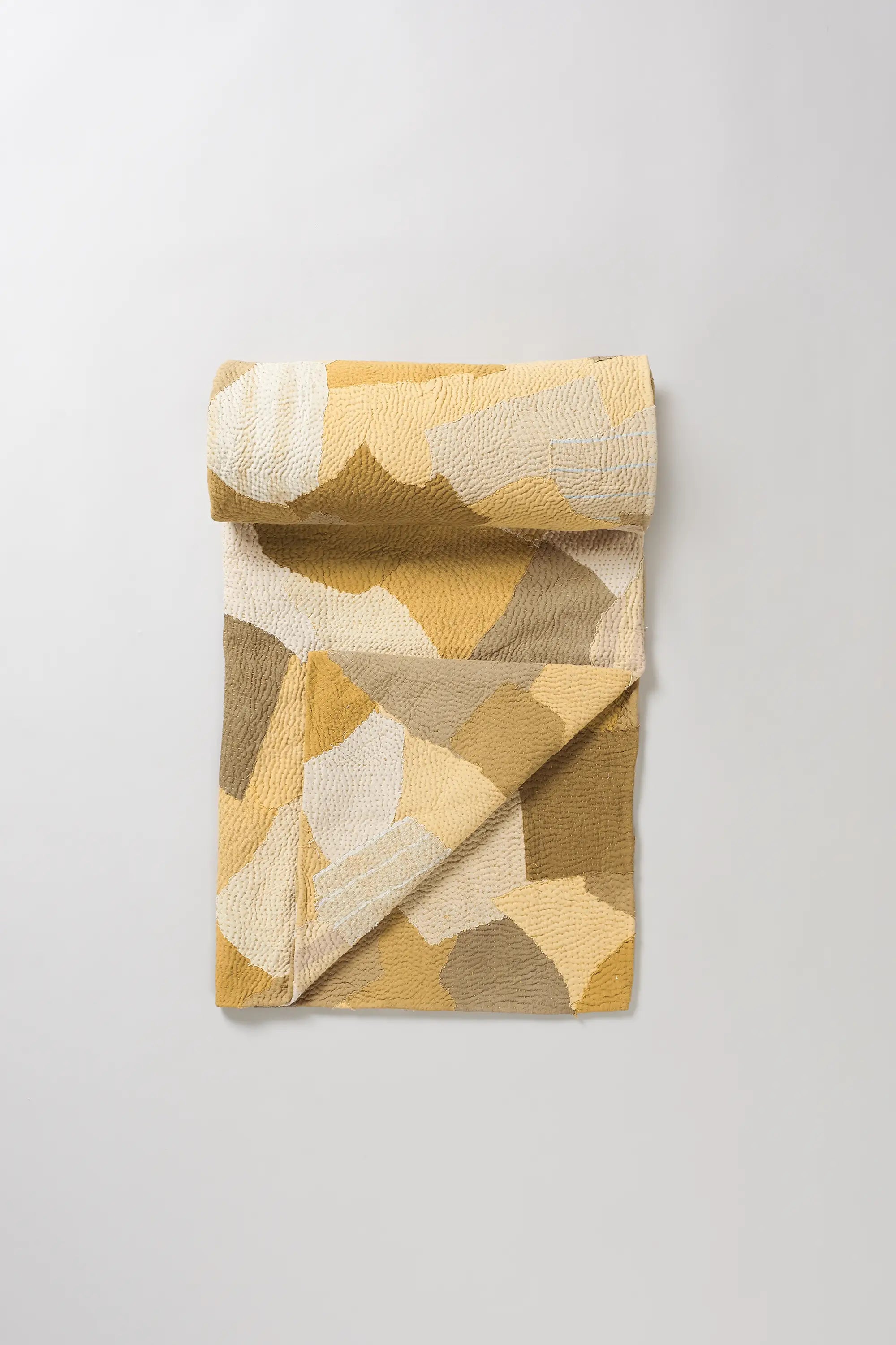 Yellow quilt roll on a light grey background
