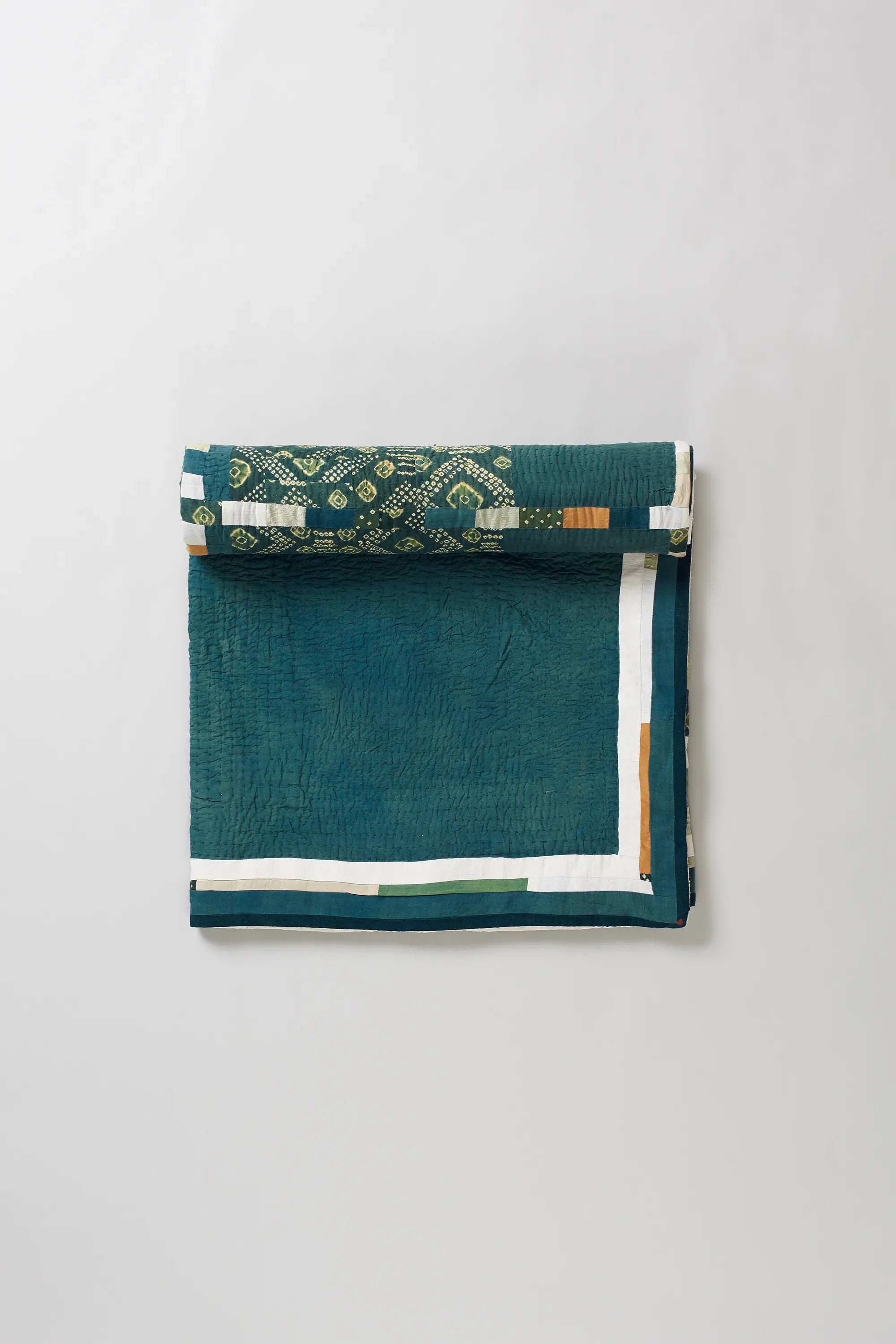 Turf green quilt roll on a light grey background