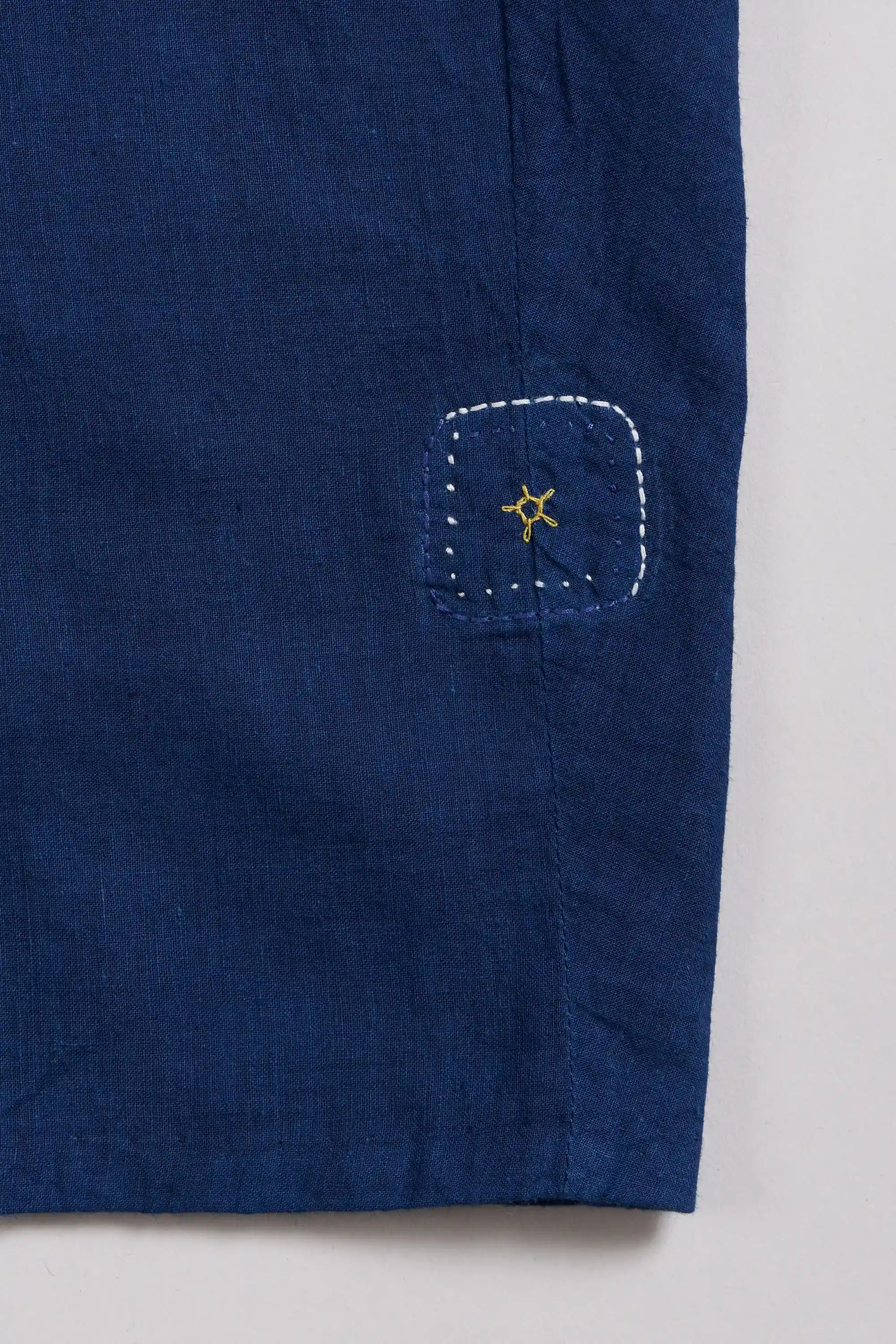 Close-up of a blue fabric with a pehchanbox on a light grey background