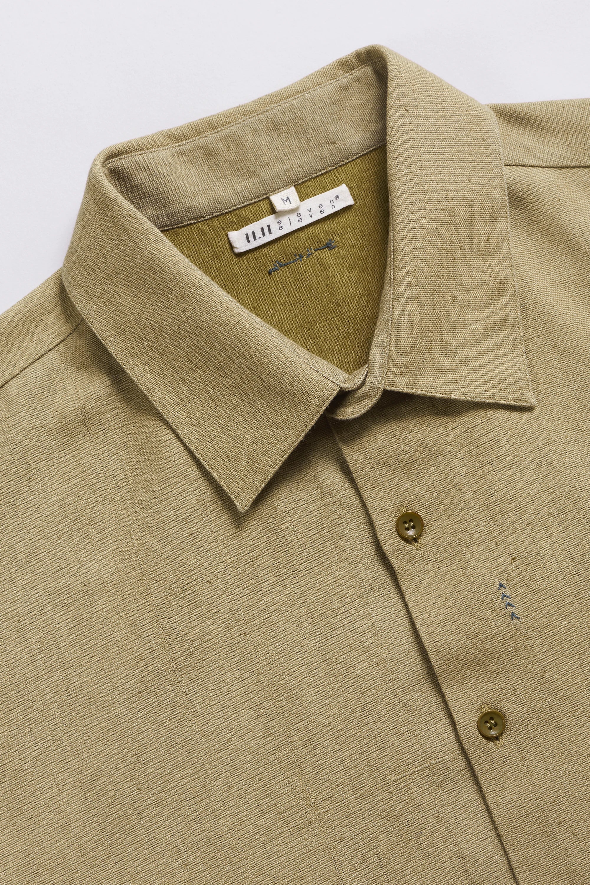 Close-up of a beige shirt with collar and buttons