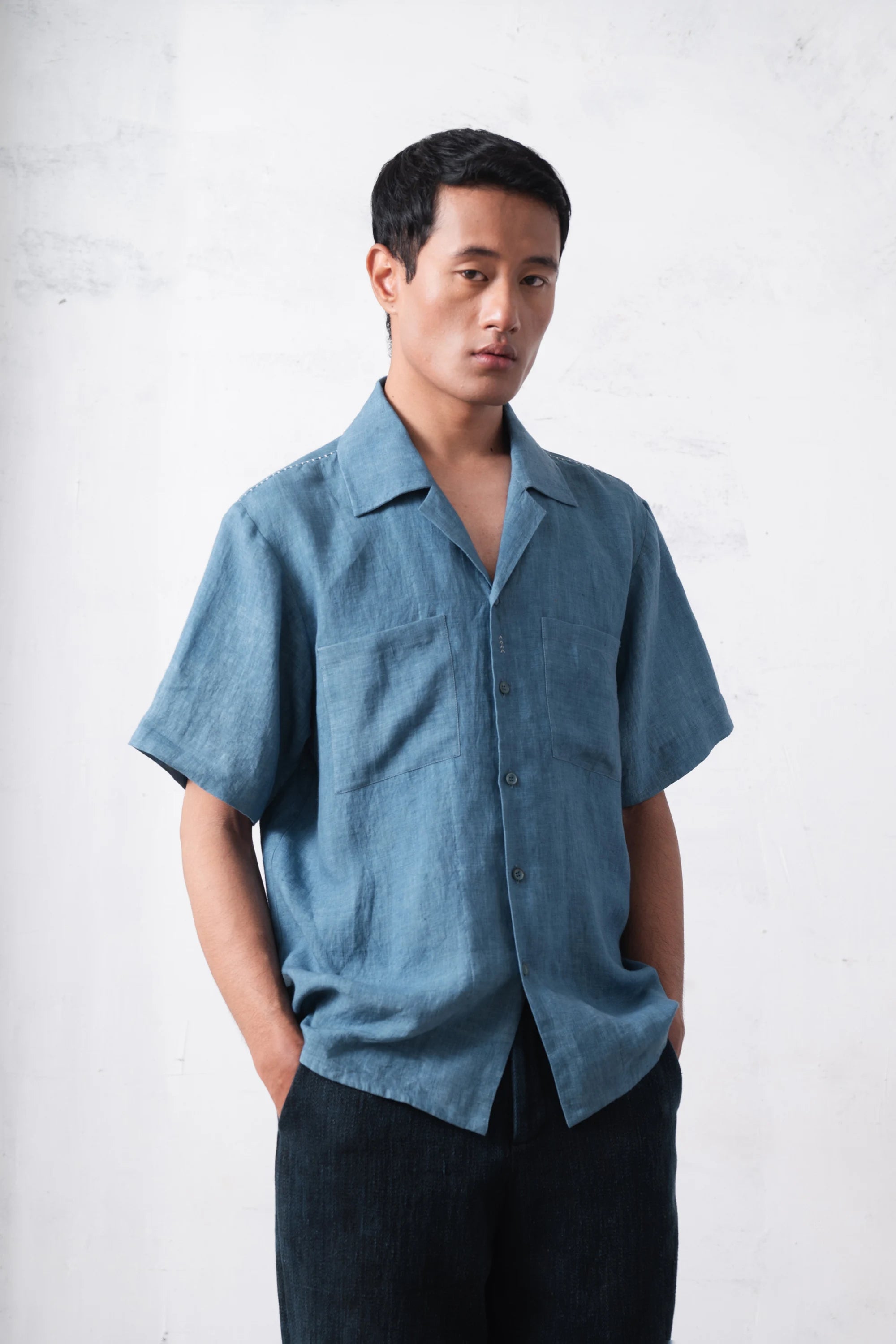 Man wearing a blue shirt on a light grey background