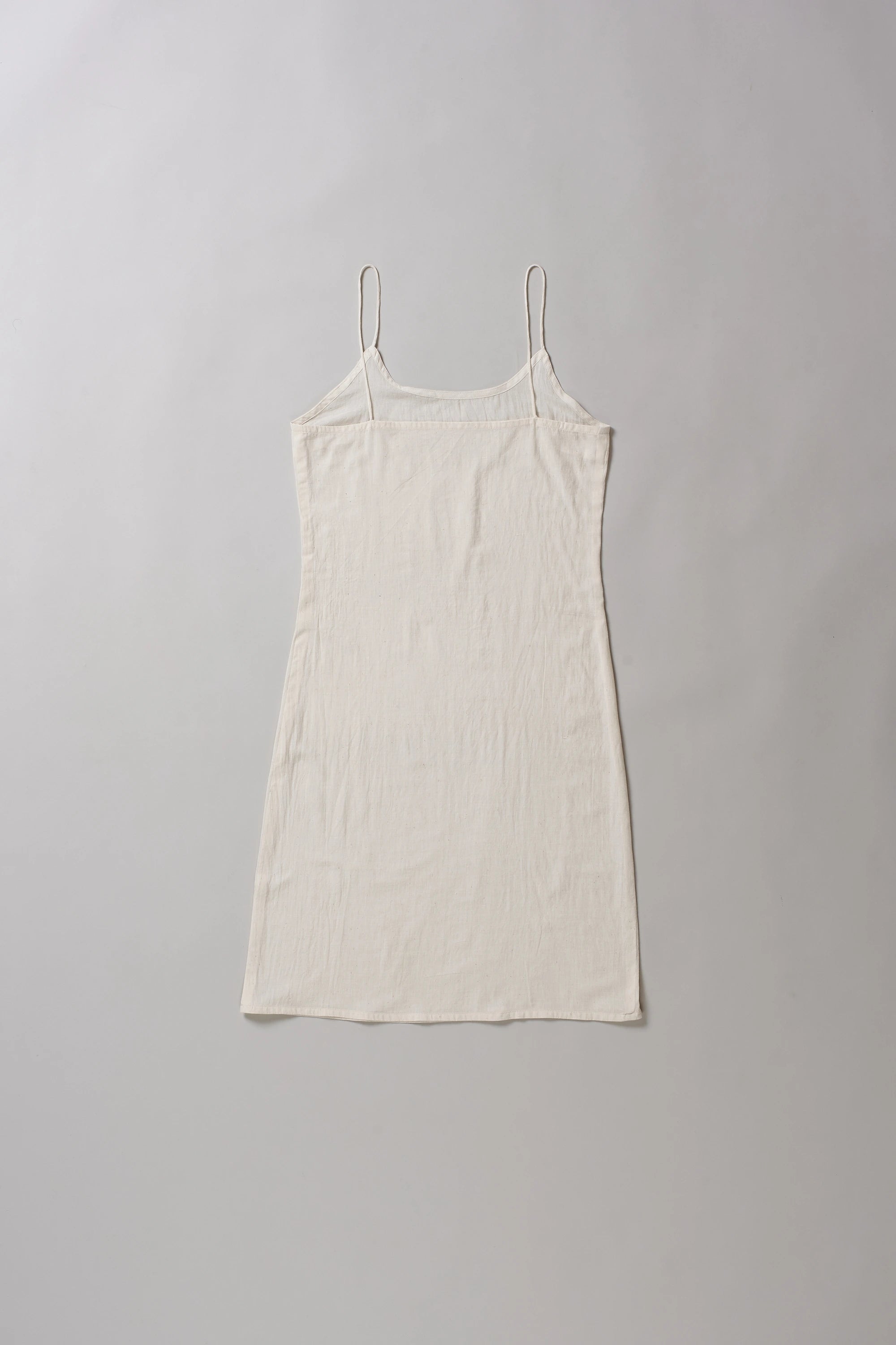 Back image of ecru cotton slip dress on a grey background