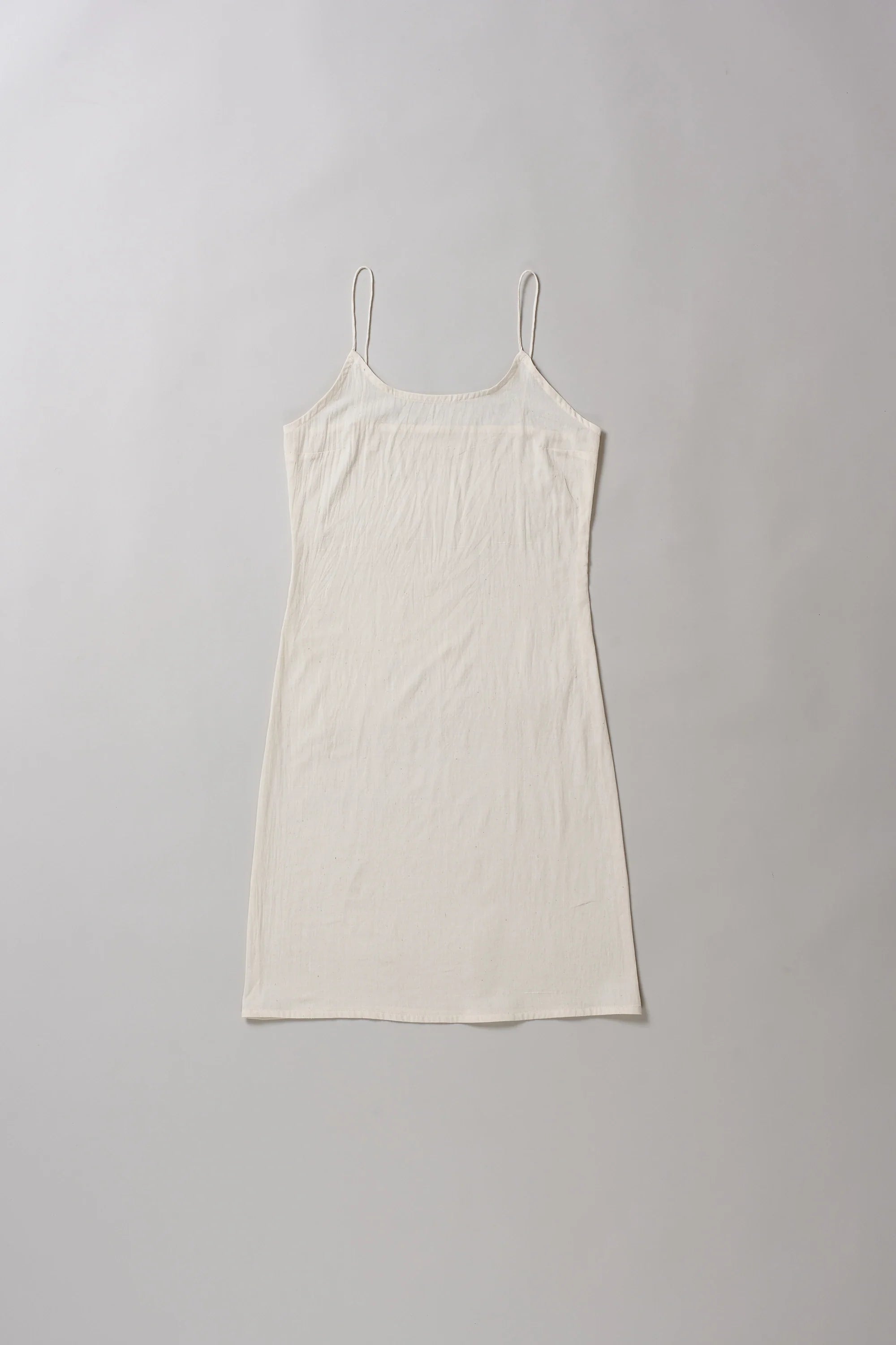 Ecru slip dress on a grey background