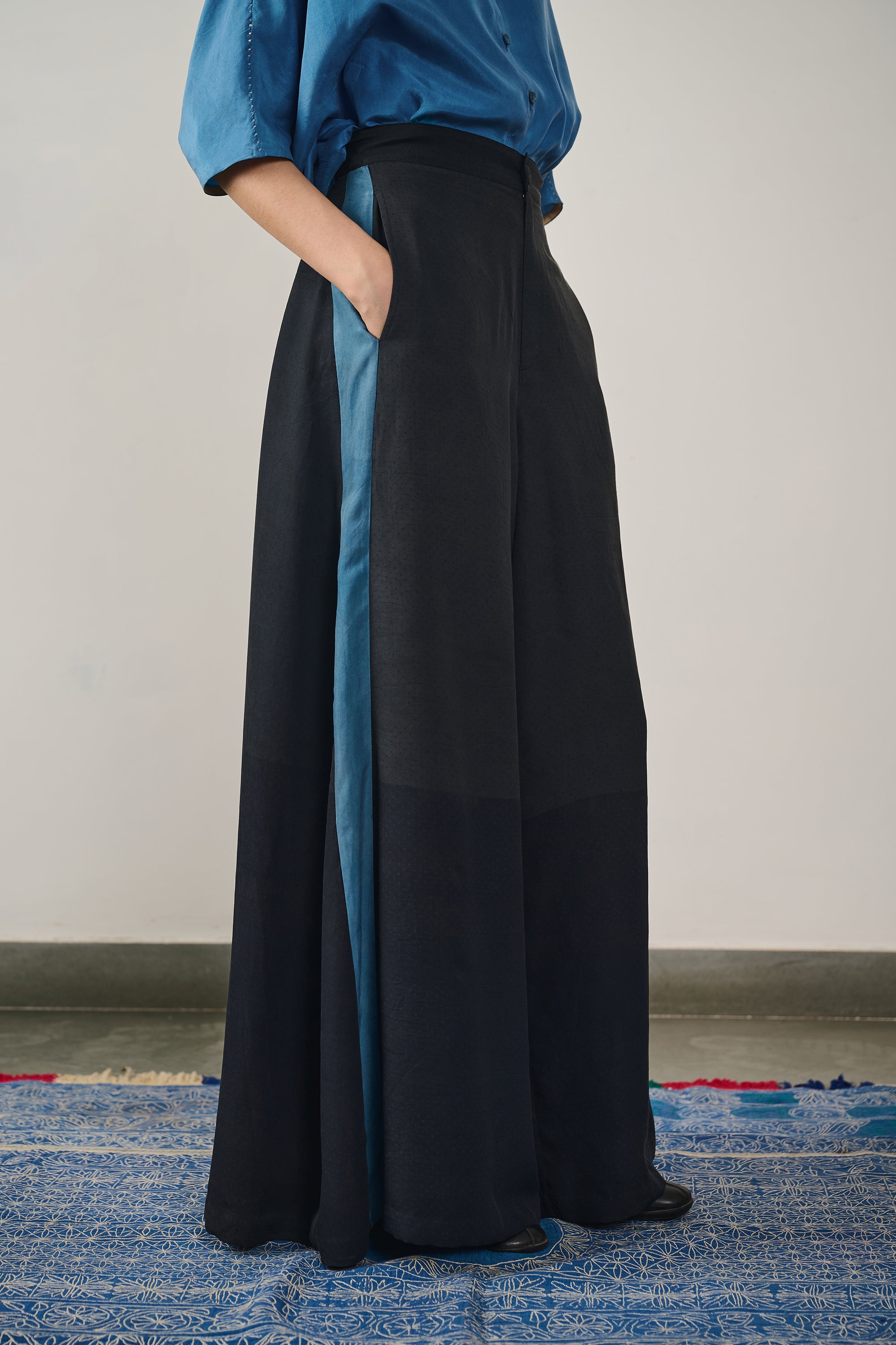 A woman wearing black silk trouser
