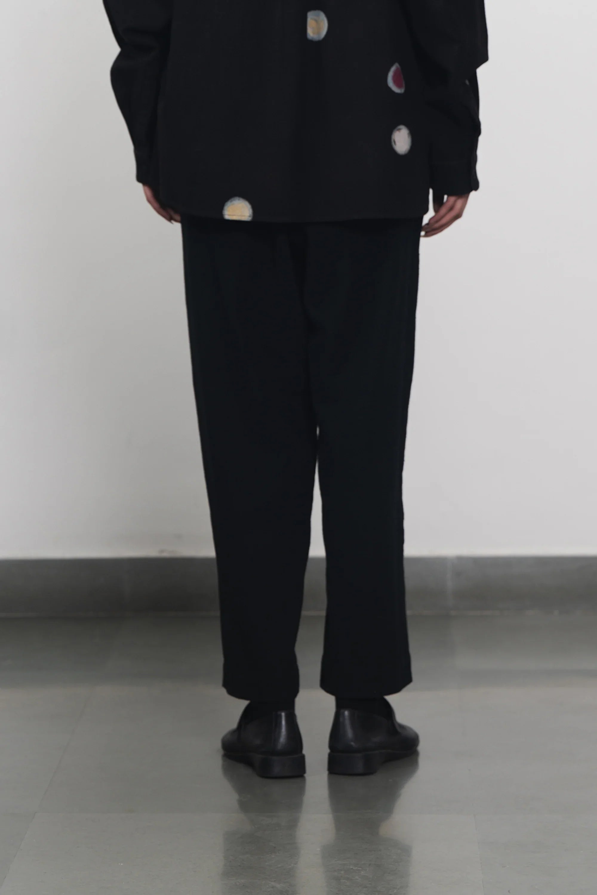 A back shot of a women wearing black pant
