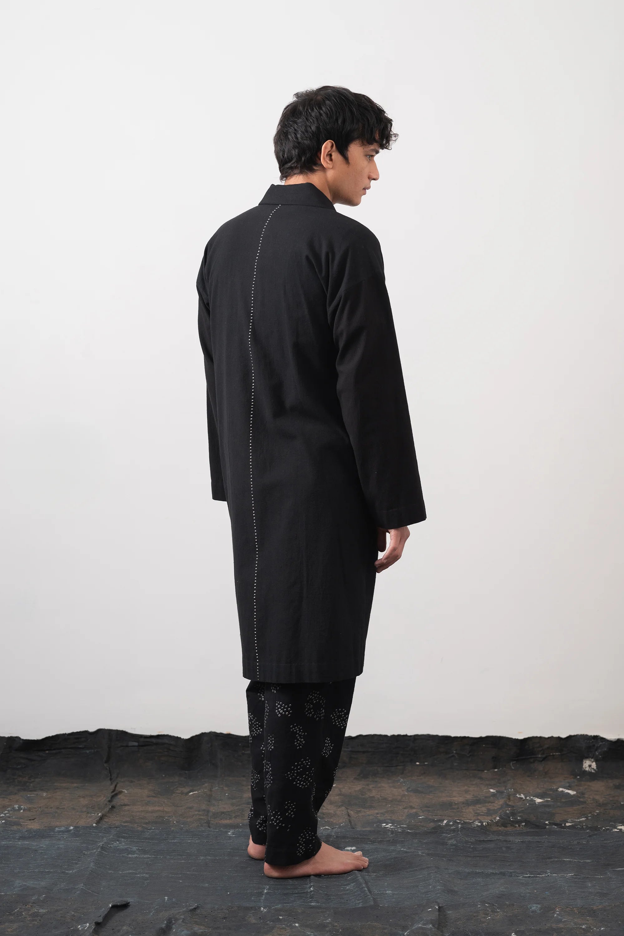 Back shot a man wearing cotton black jacket with hand detail