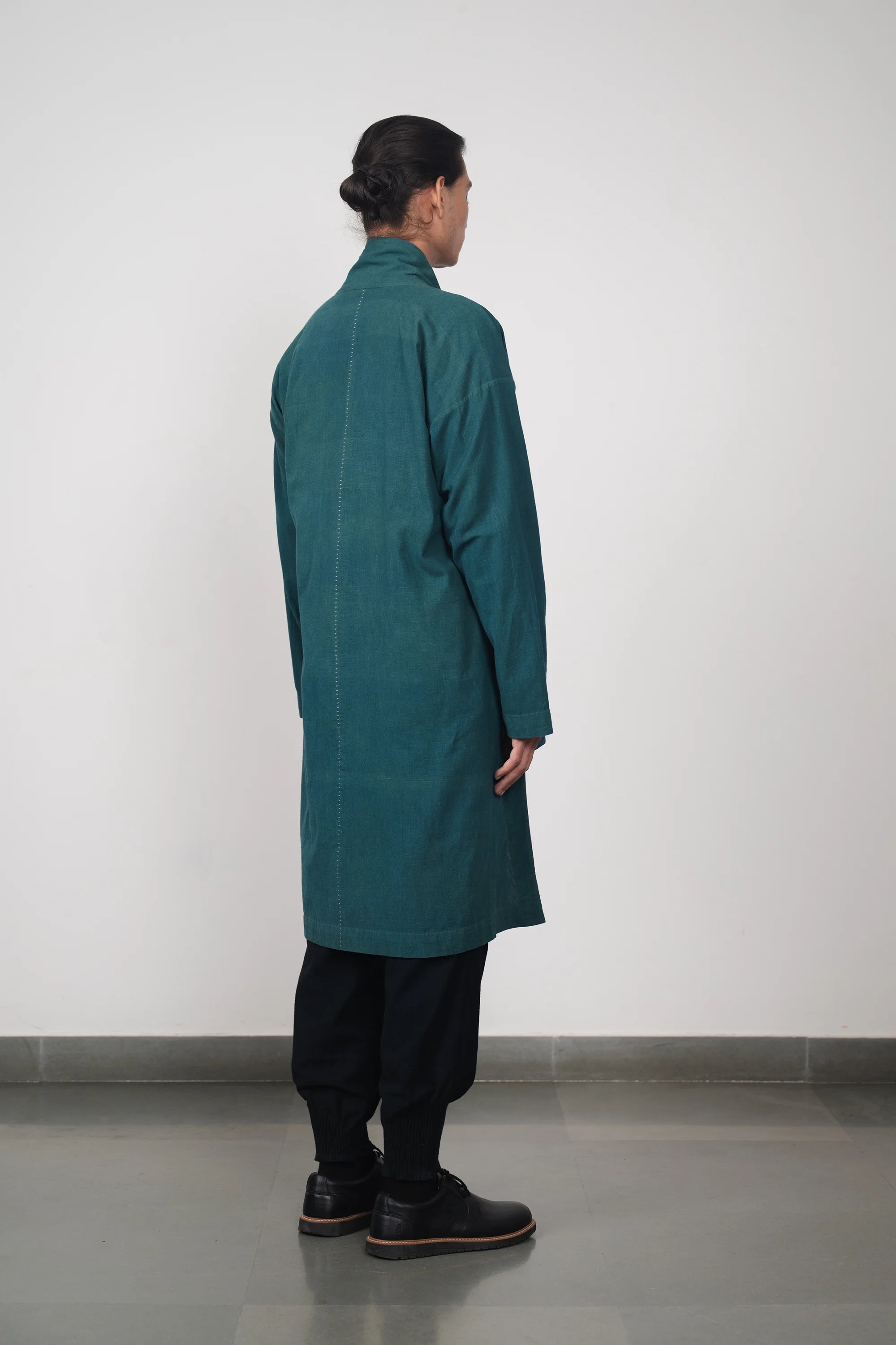 A back shot of a man wearing bottle green jacket