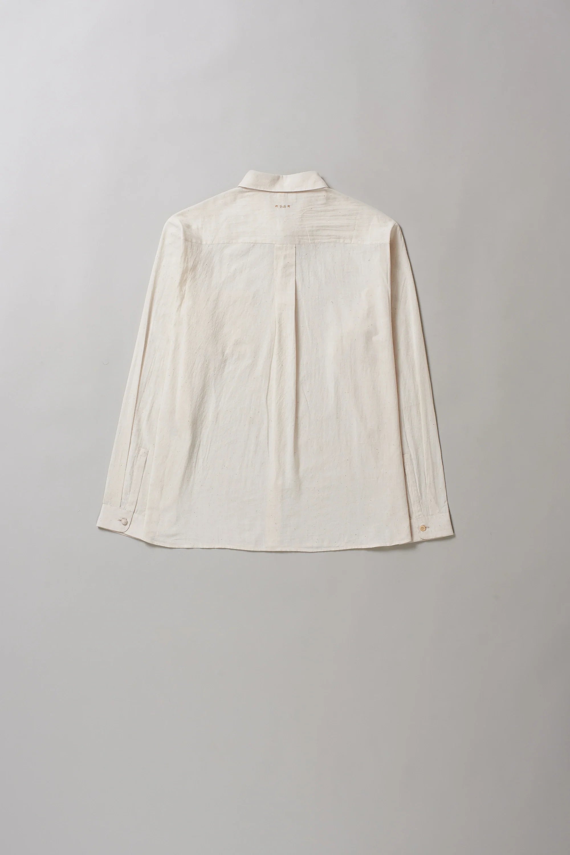 Back image of ecru shirt on a grey background