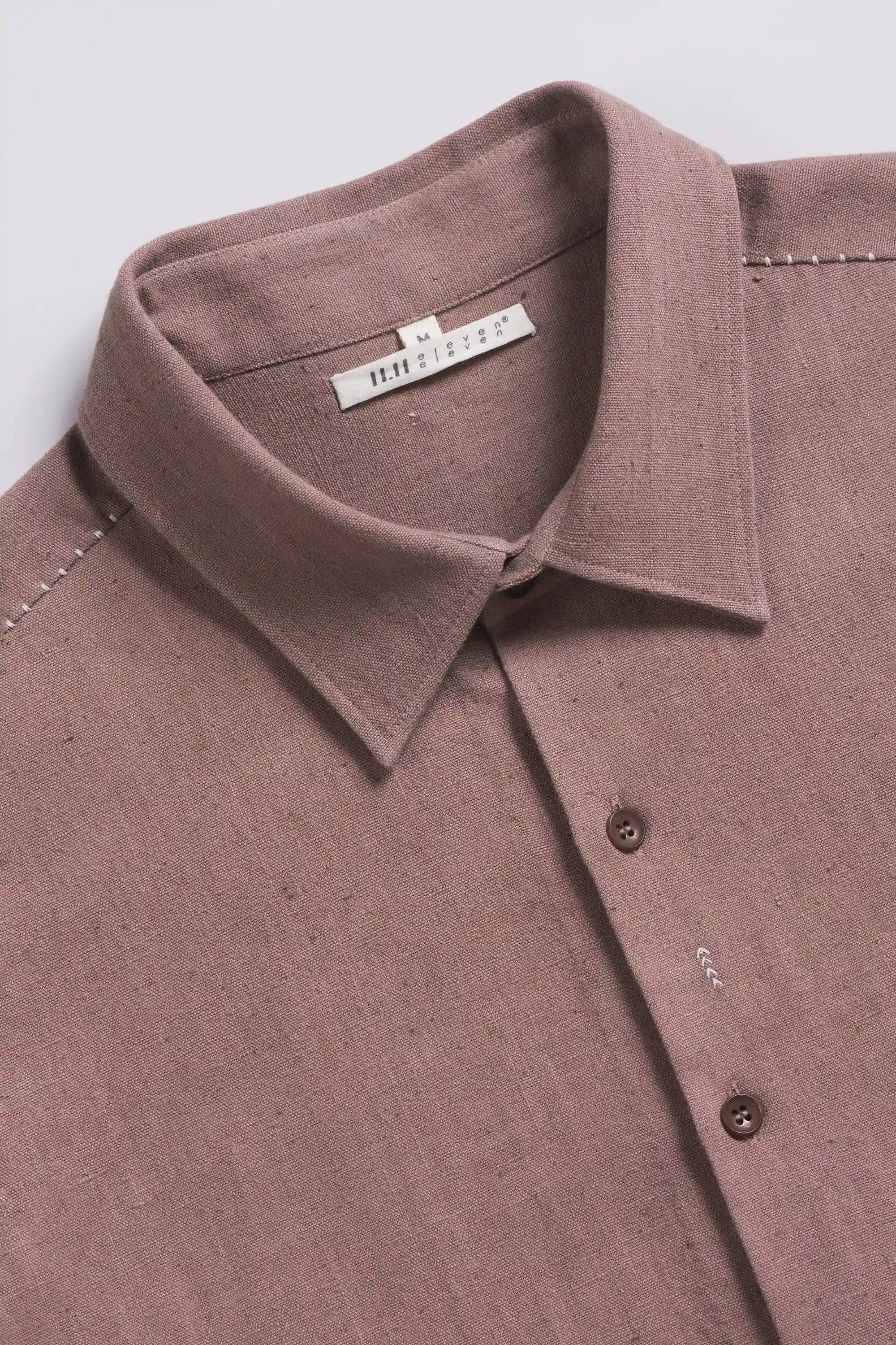 Close-up of a old rose shirt with collar and buttons on a light grey background