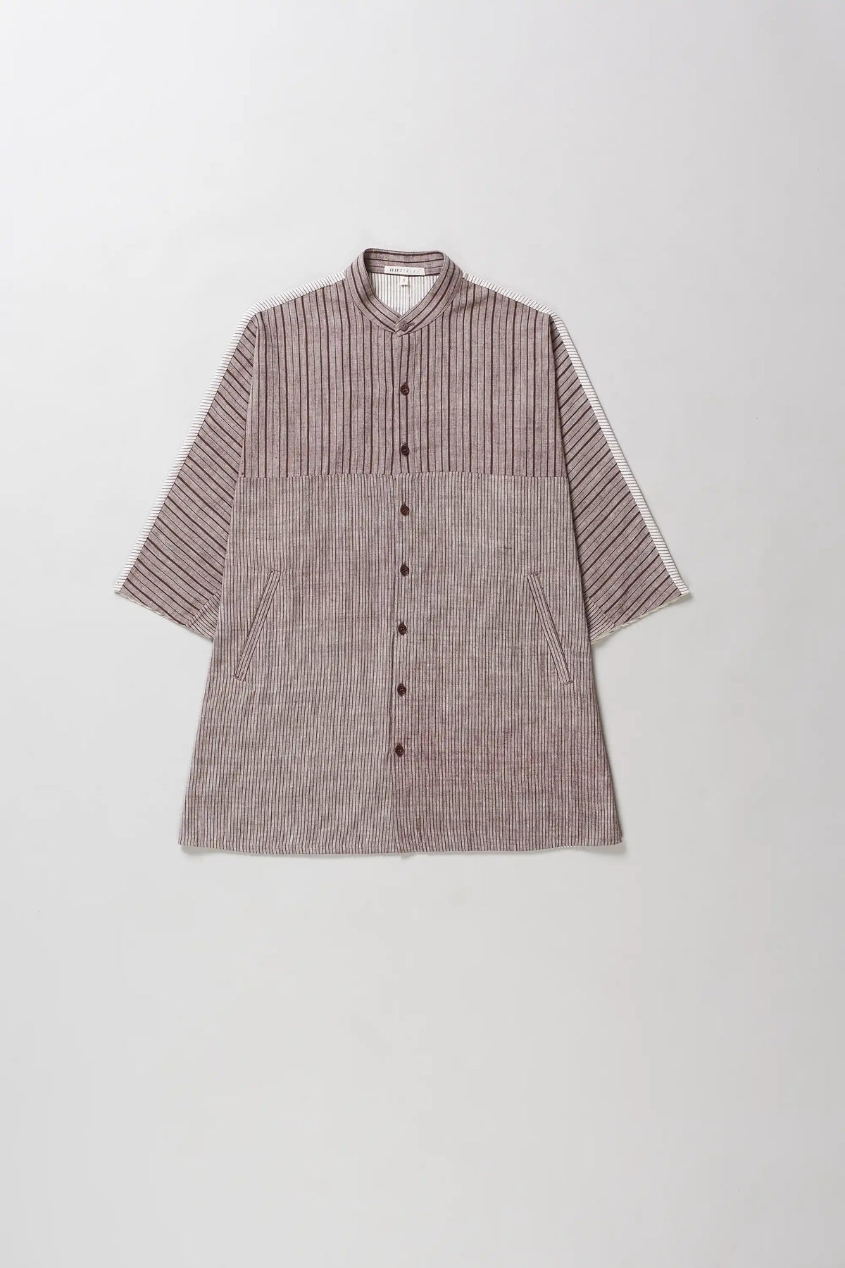 A short-sleeve button-front shirt with a mandarin collar, featuring a vertically striped textured upper chest and shoulders and a solid woven lower body in a muted mauve-brown color.