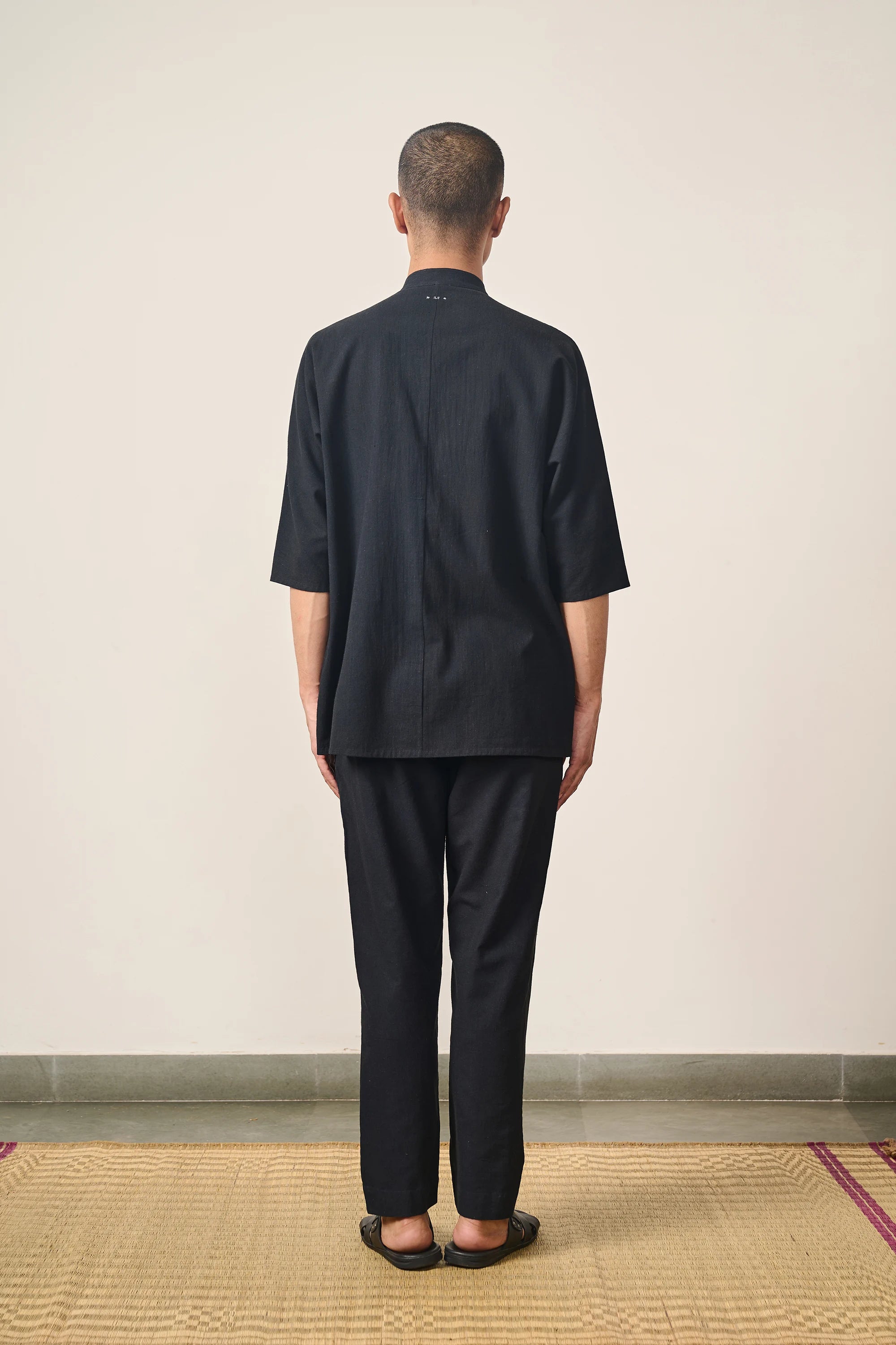 A back shot of a man wearing back cotton shirt