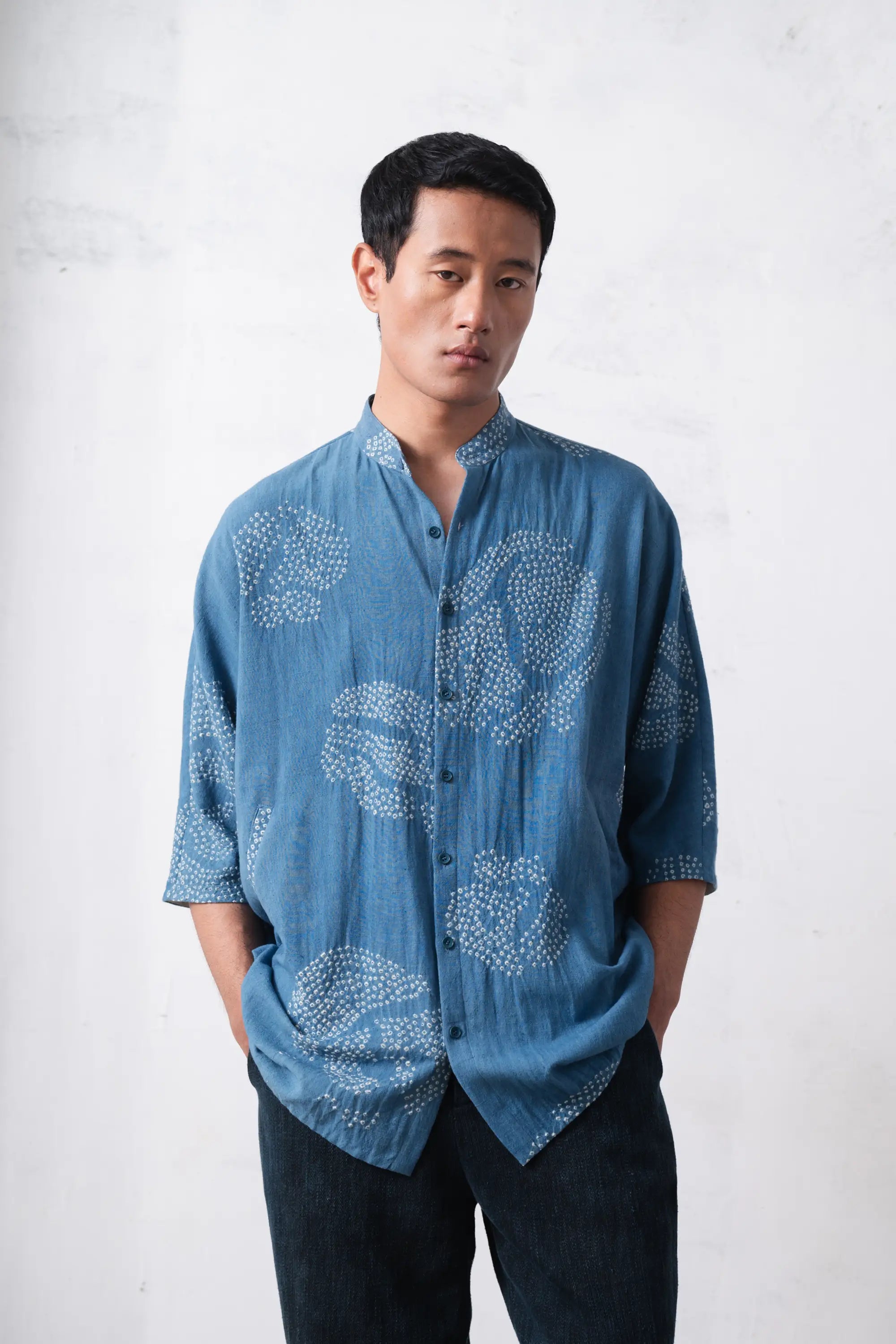 Man wearing a blue bandhani shirt against a light grey background