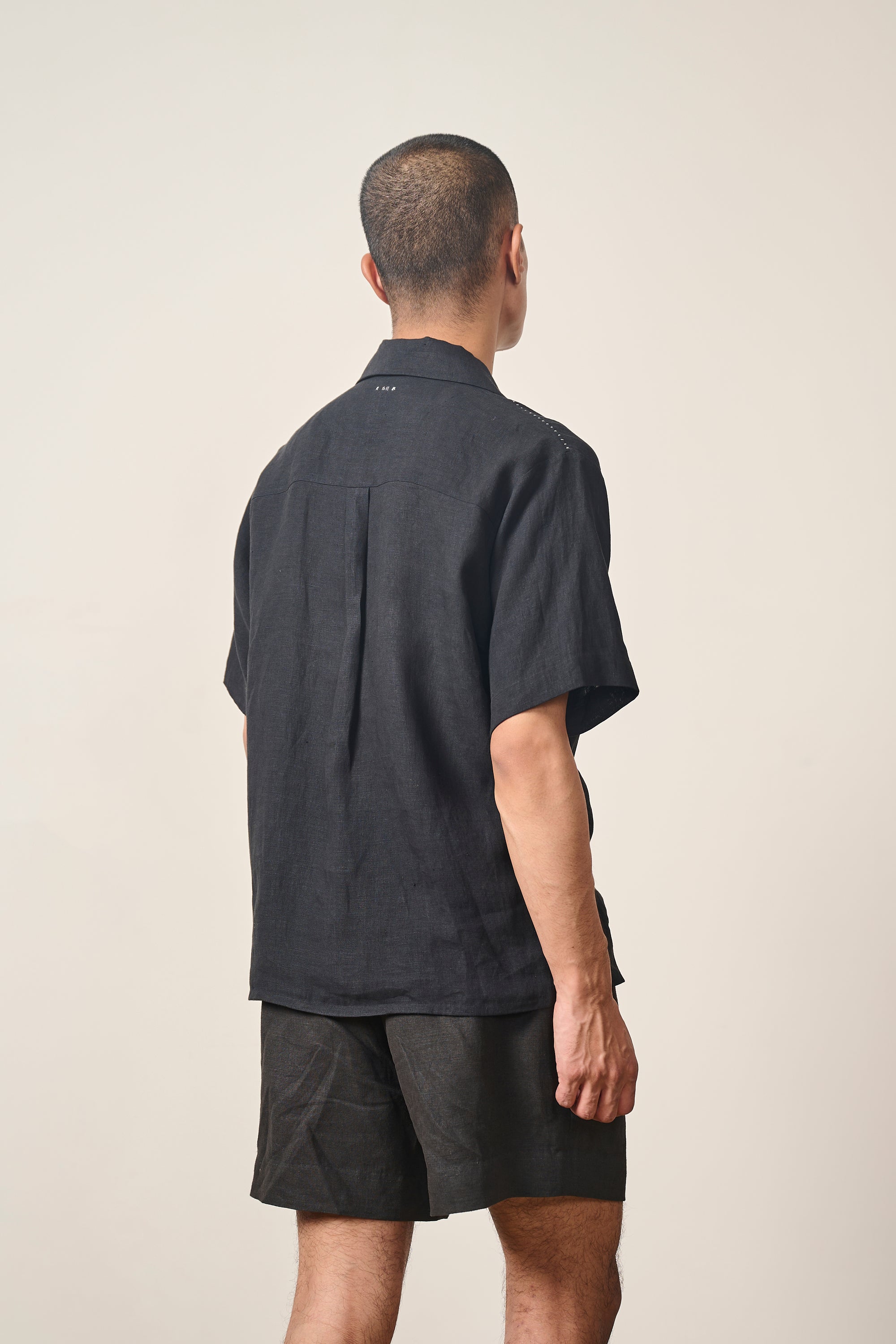 A back shot of a man wearing black shorts