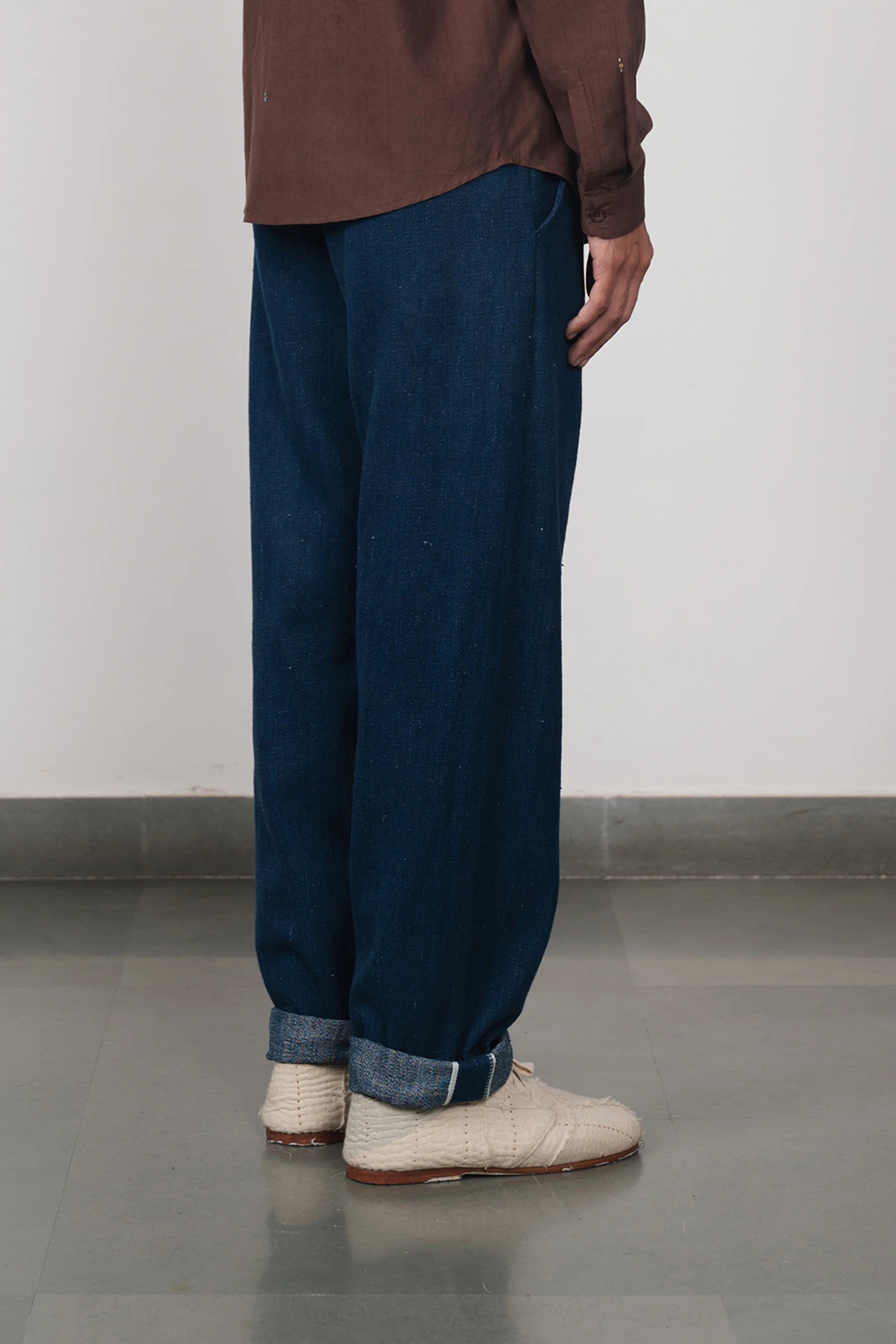 A back shot of a man wearing indigo pant