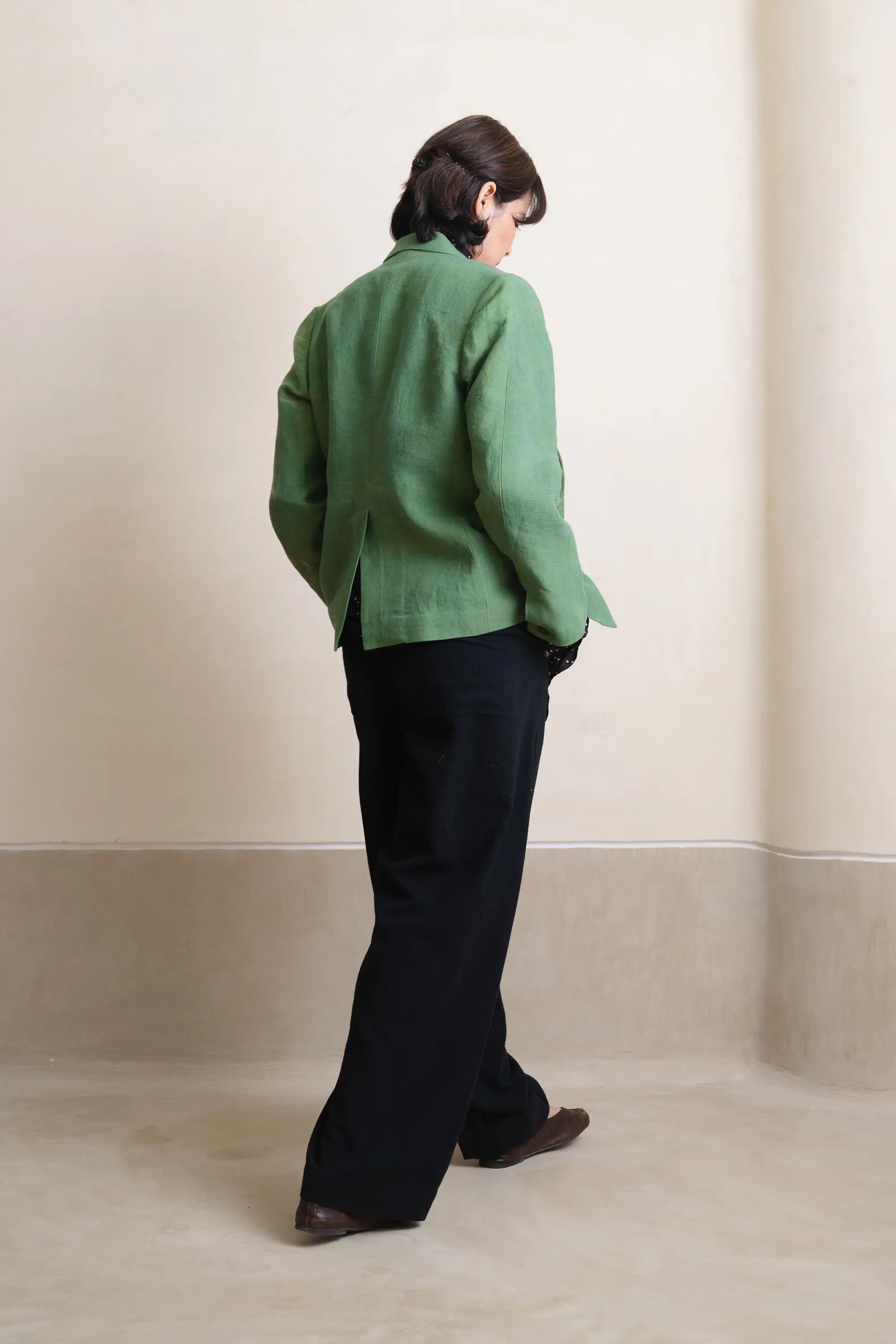 A back shot of woman wearing turf green linen jacket