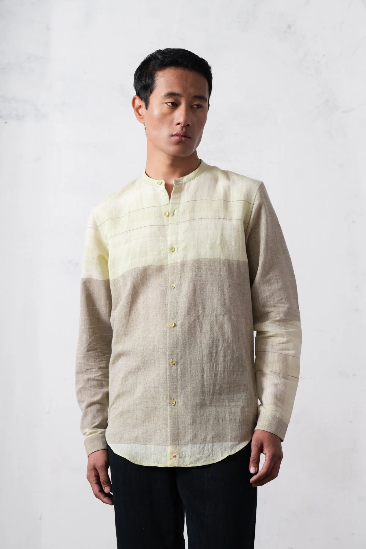 Man wearing a khaki green shirt against a plain background
