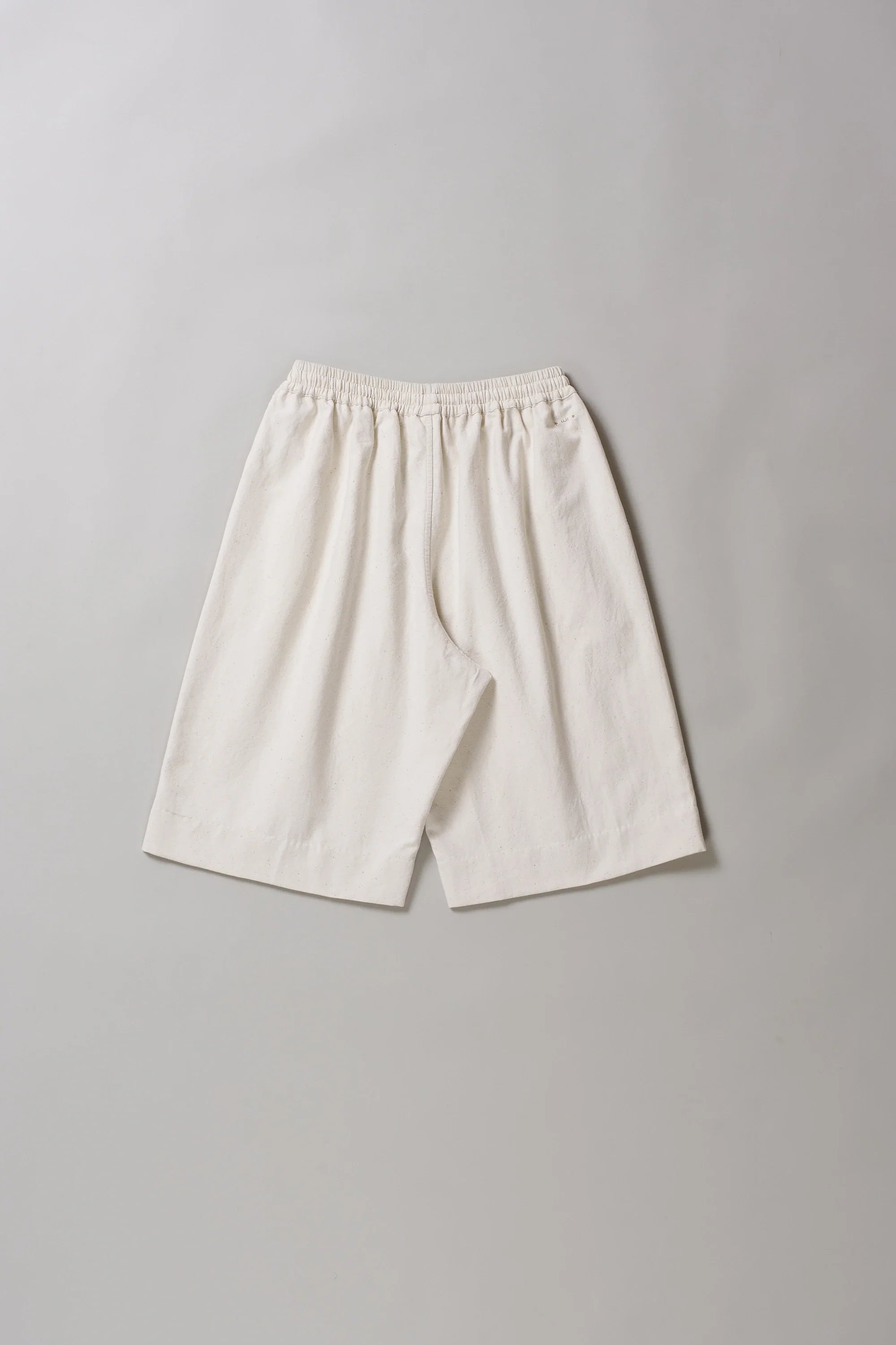 Ecru cotton shorts on a grey background