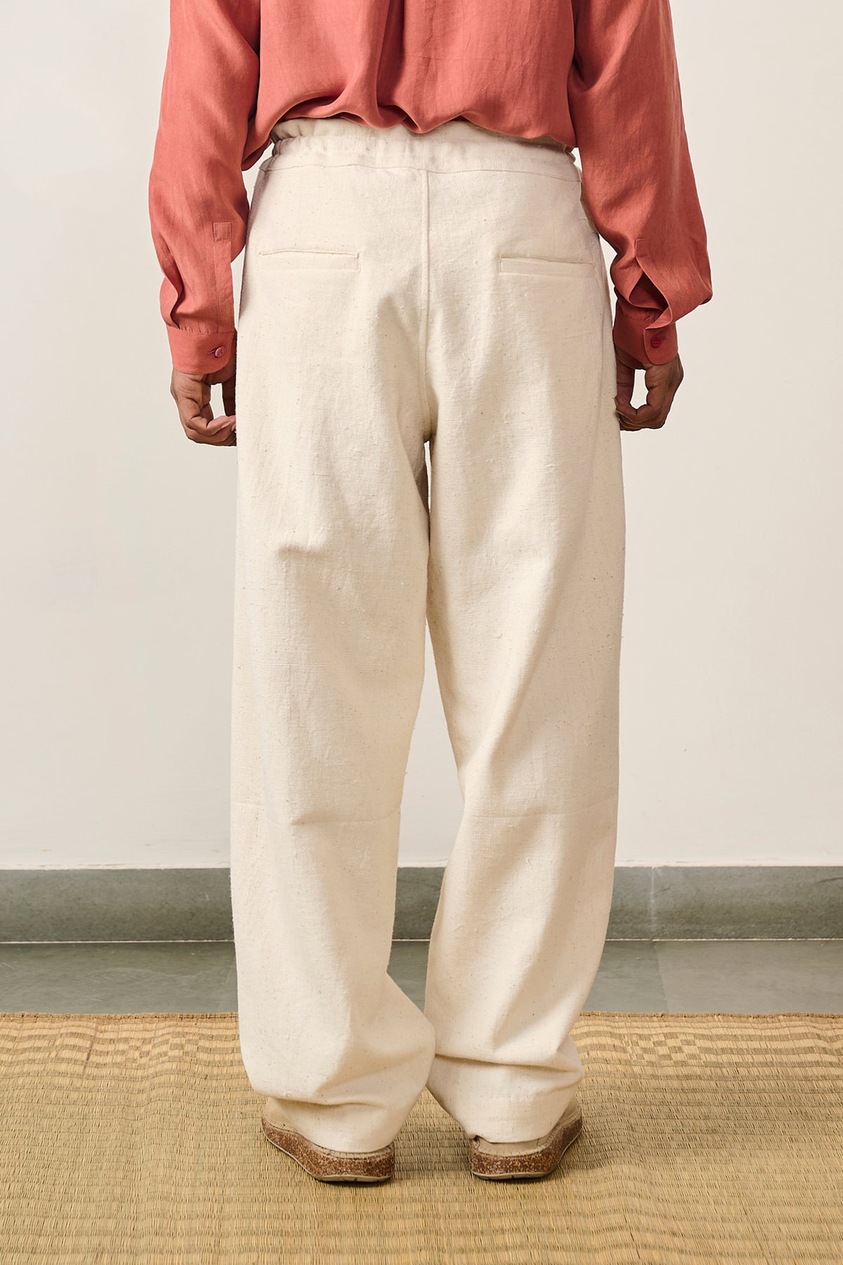 A back shot of a man wearing ecru cotton pant