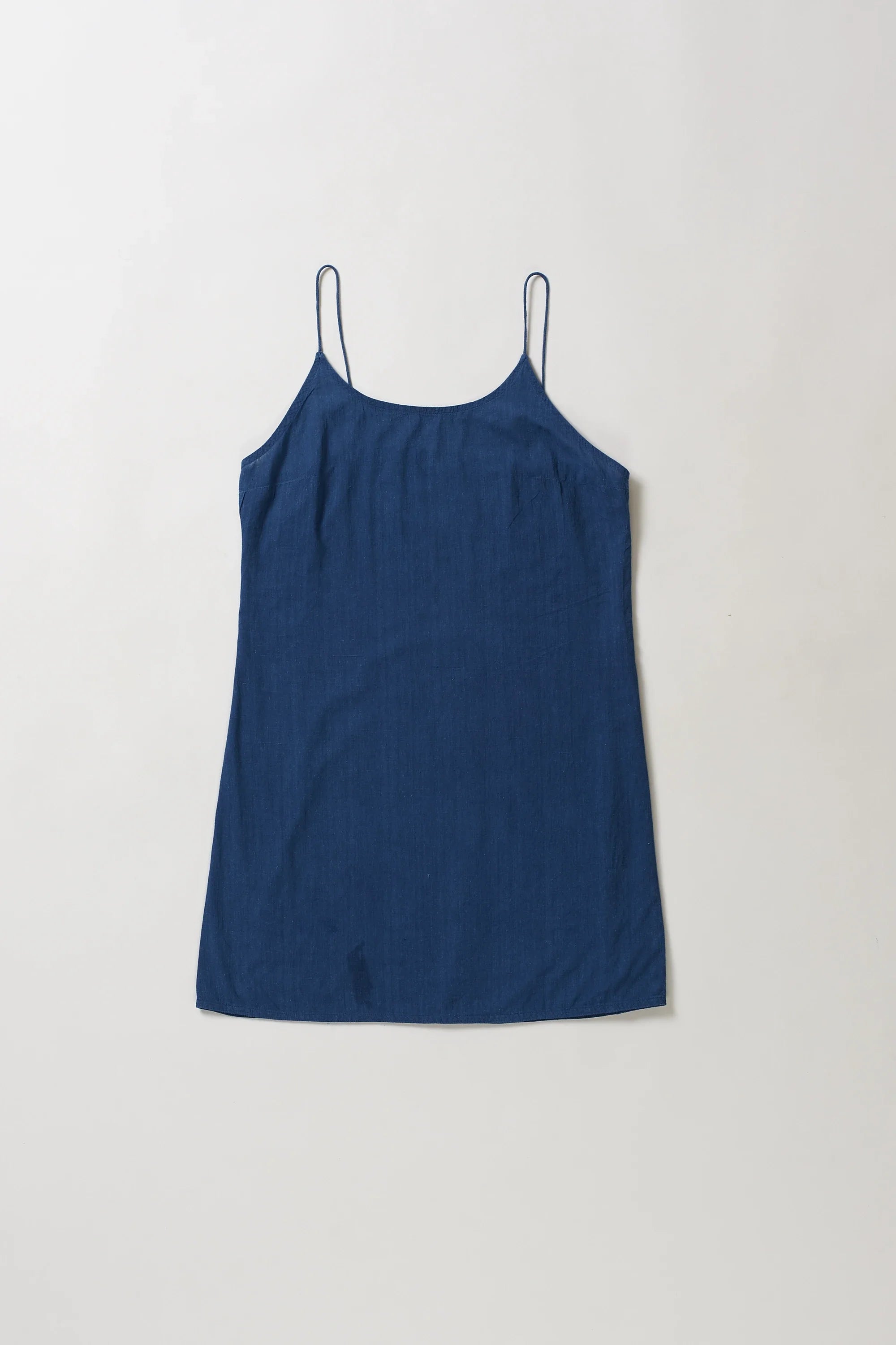 Blue slip dress on a light grey background