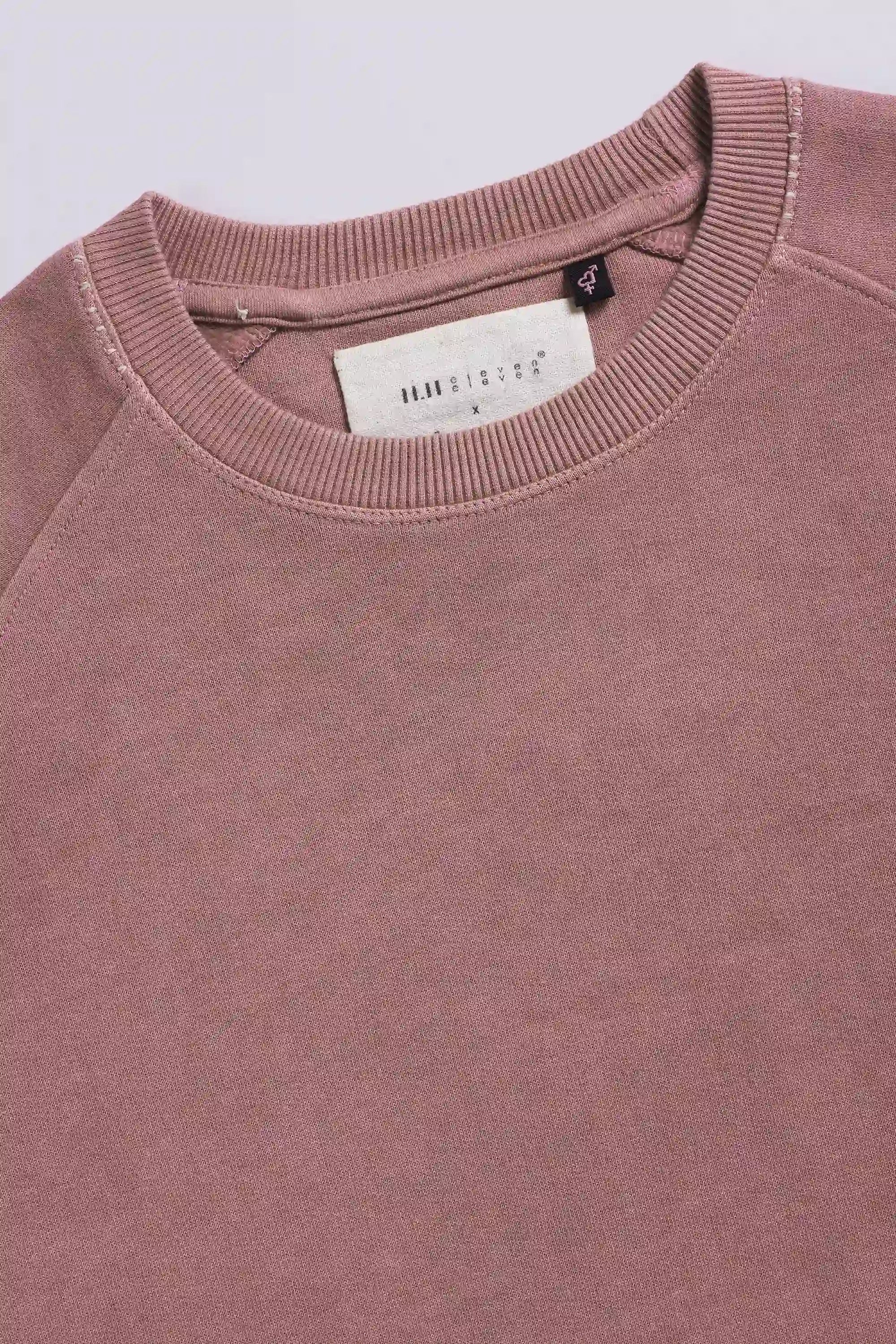 Close-up of a sweatshirt with a brand label on a light grey background