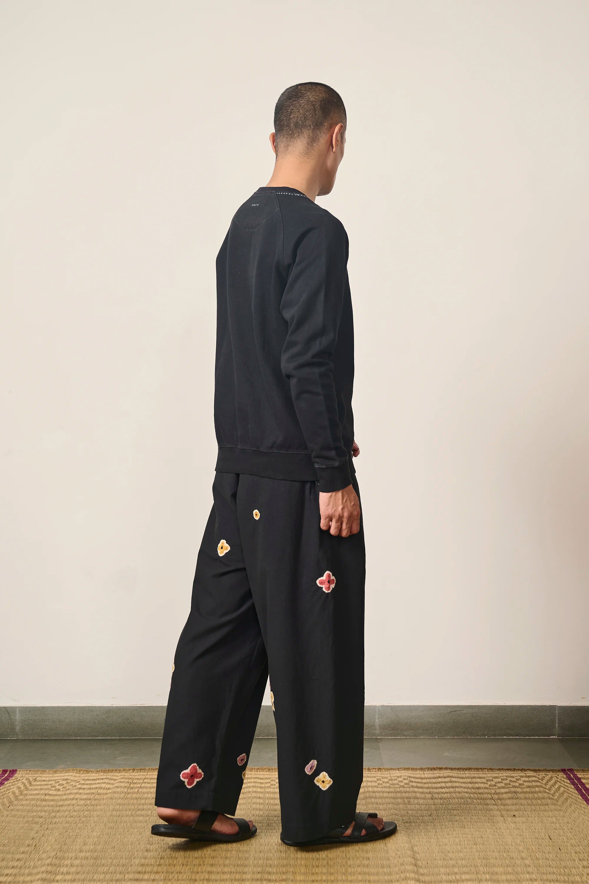A side shot of a man wearing back cotton sweatshirt
