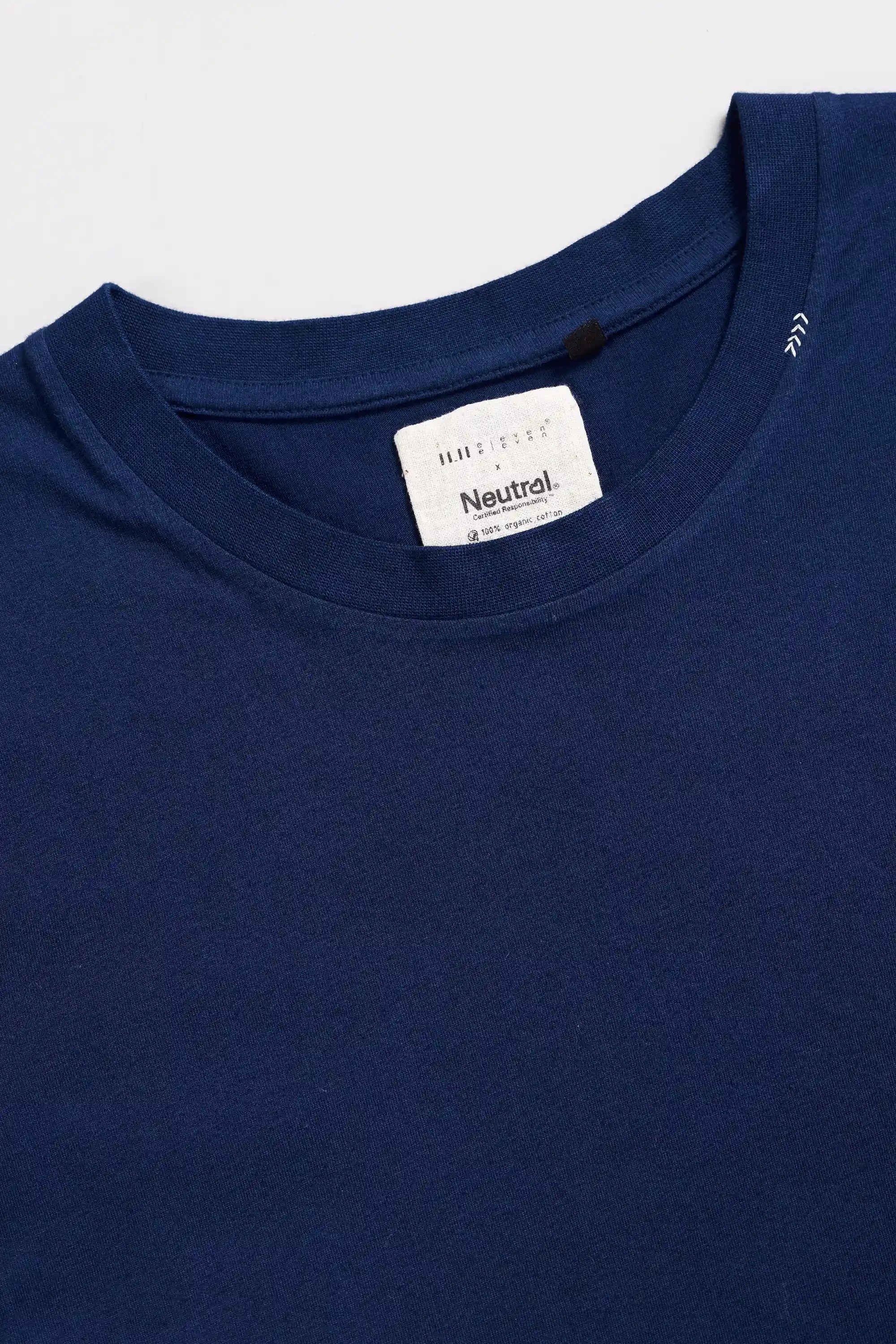 Close-up of a blue t-shirt with hand detail on a light grey background