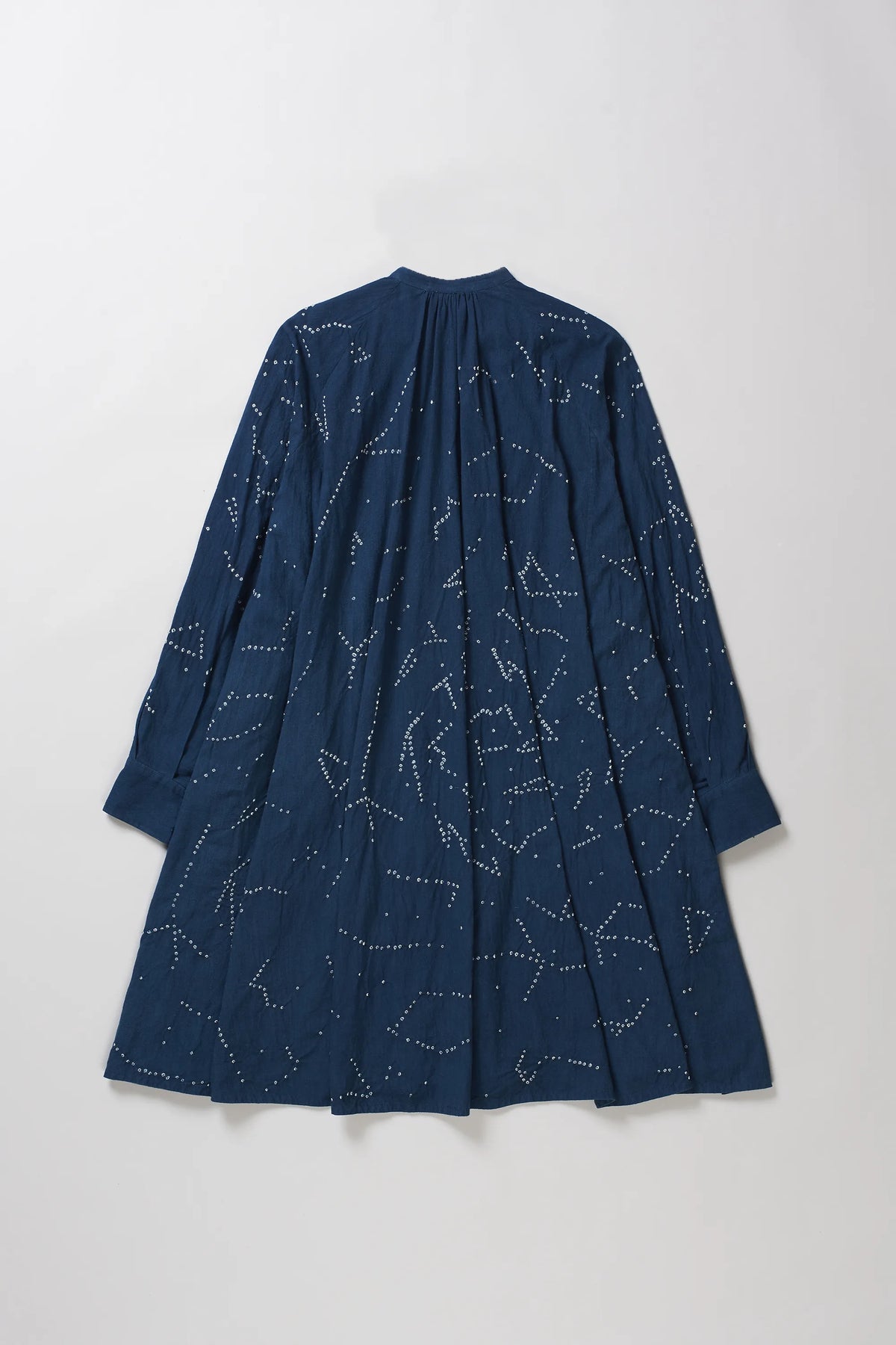 A space blue long-sleeve dress with a bandhani pattern, featuring a gathered high neckline, shown against a plain grey background.