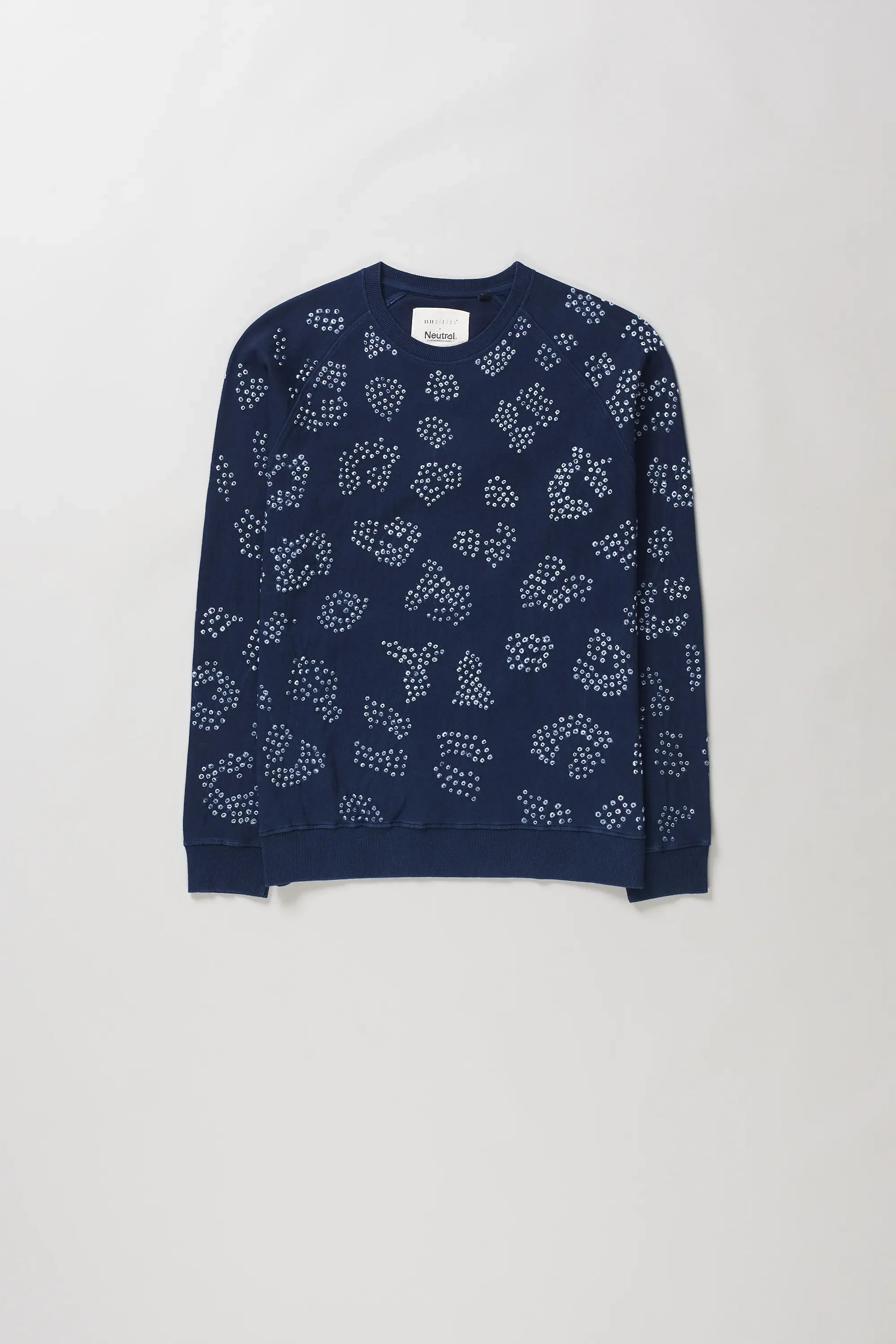 Indigo crewneck sweatshirt with an all-over white dotted abstract pattern bandhani, laid flat against a light grey background.