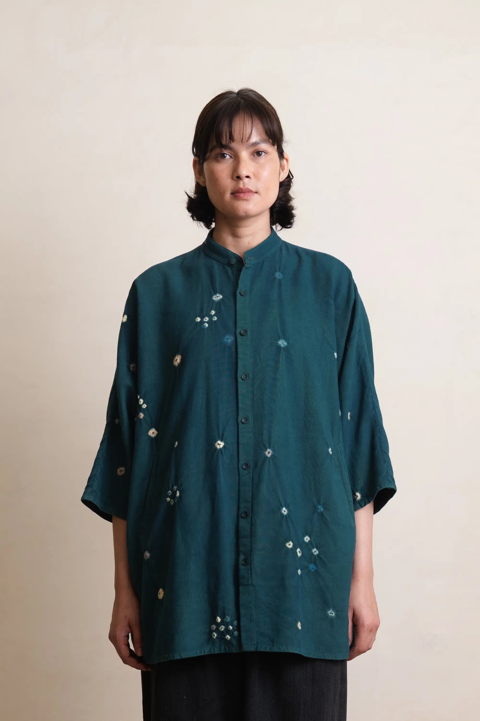 A woman wearing cotton leaf green shirt