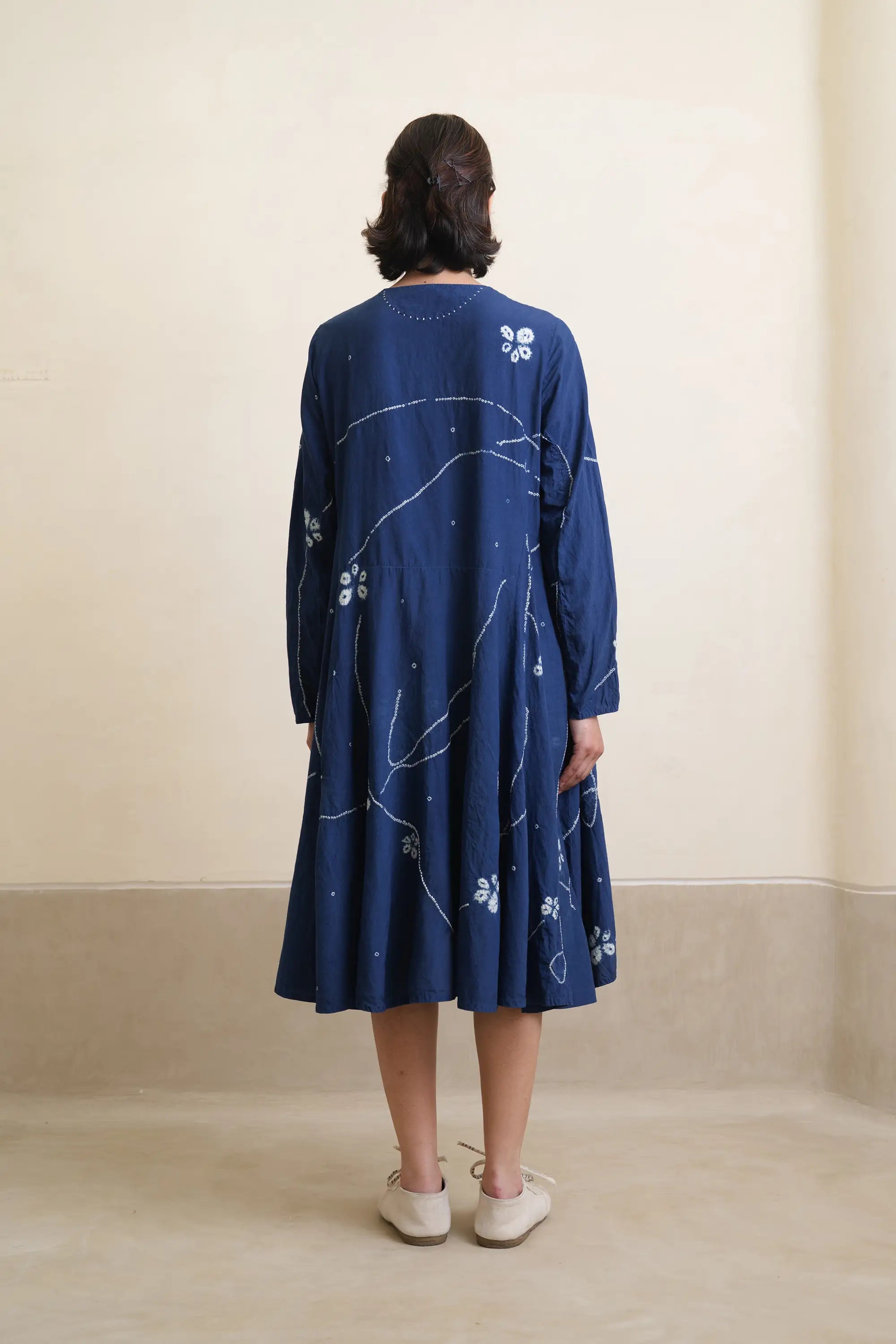 A back shot of woman wearing medium indigo dress