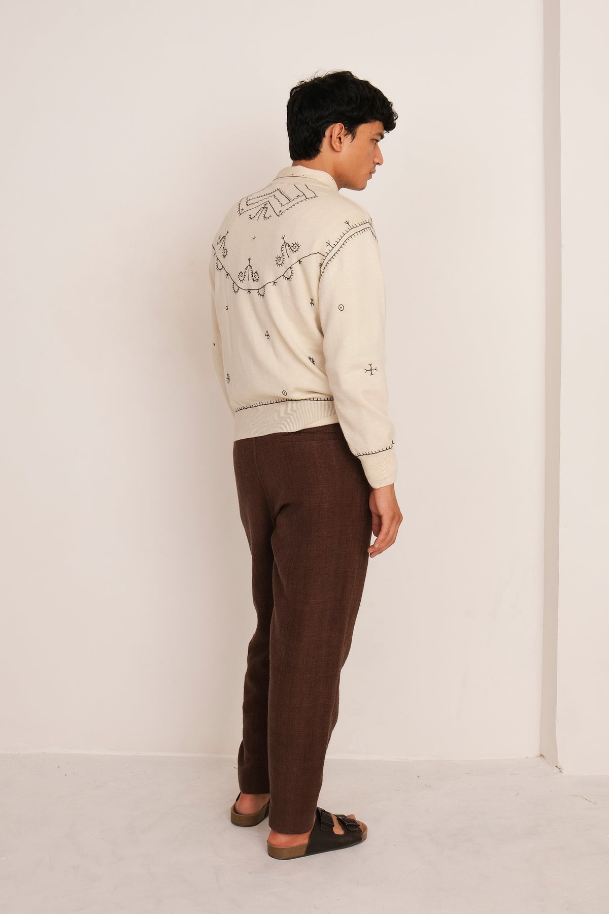 A back shot of a man wearing ecru sweatshirt shirt