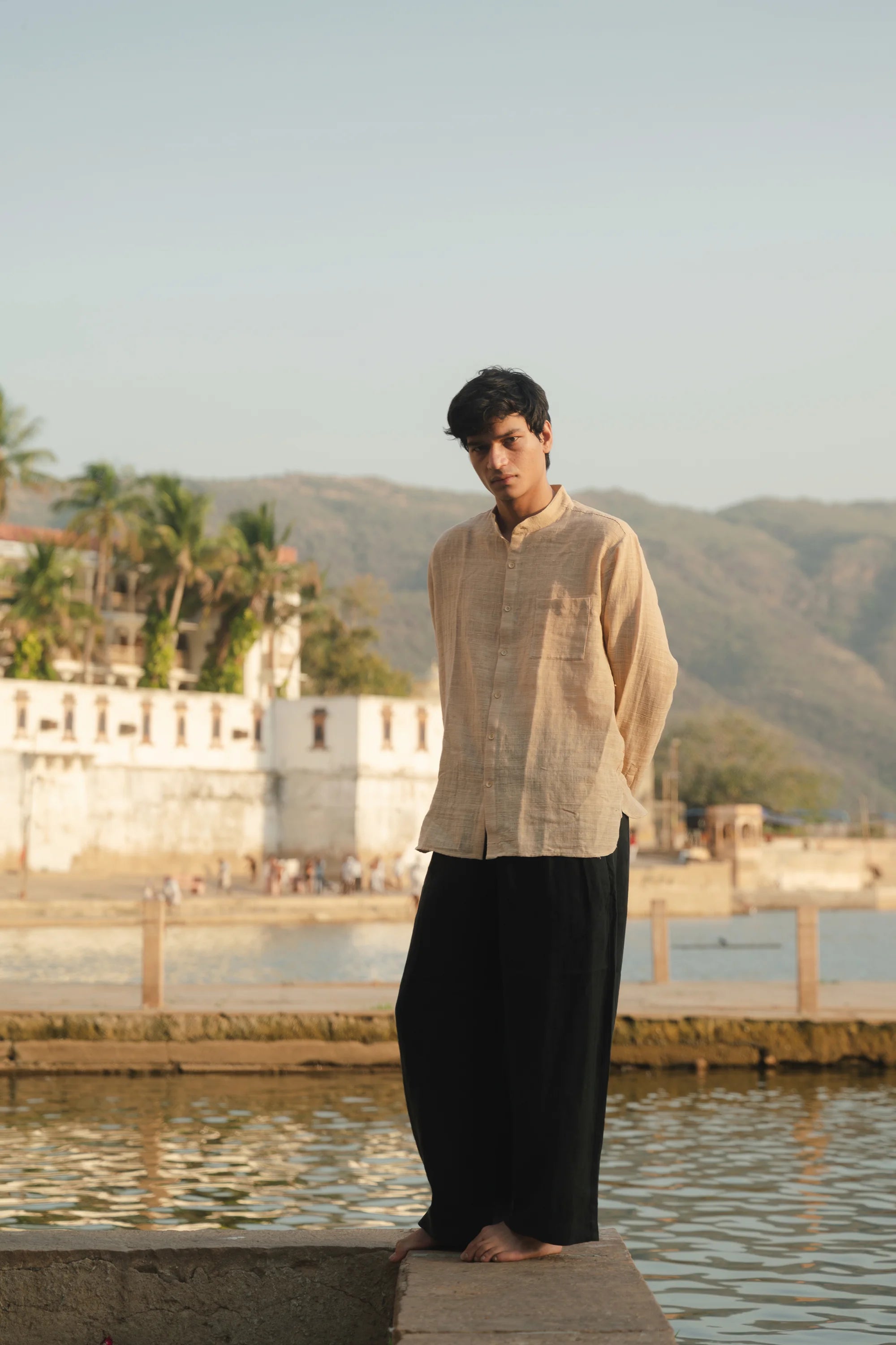 A man wearing ecru cotton shirt with black pant