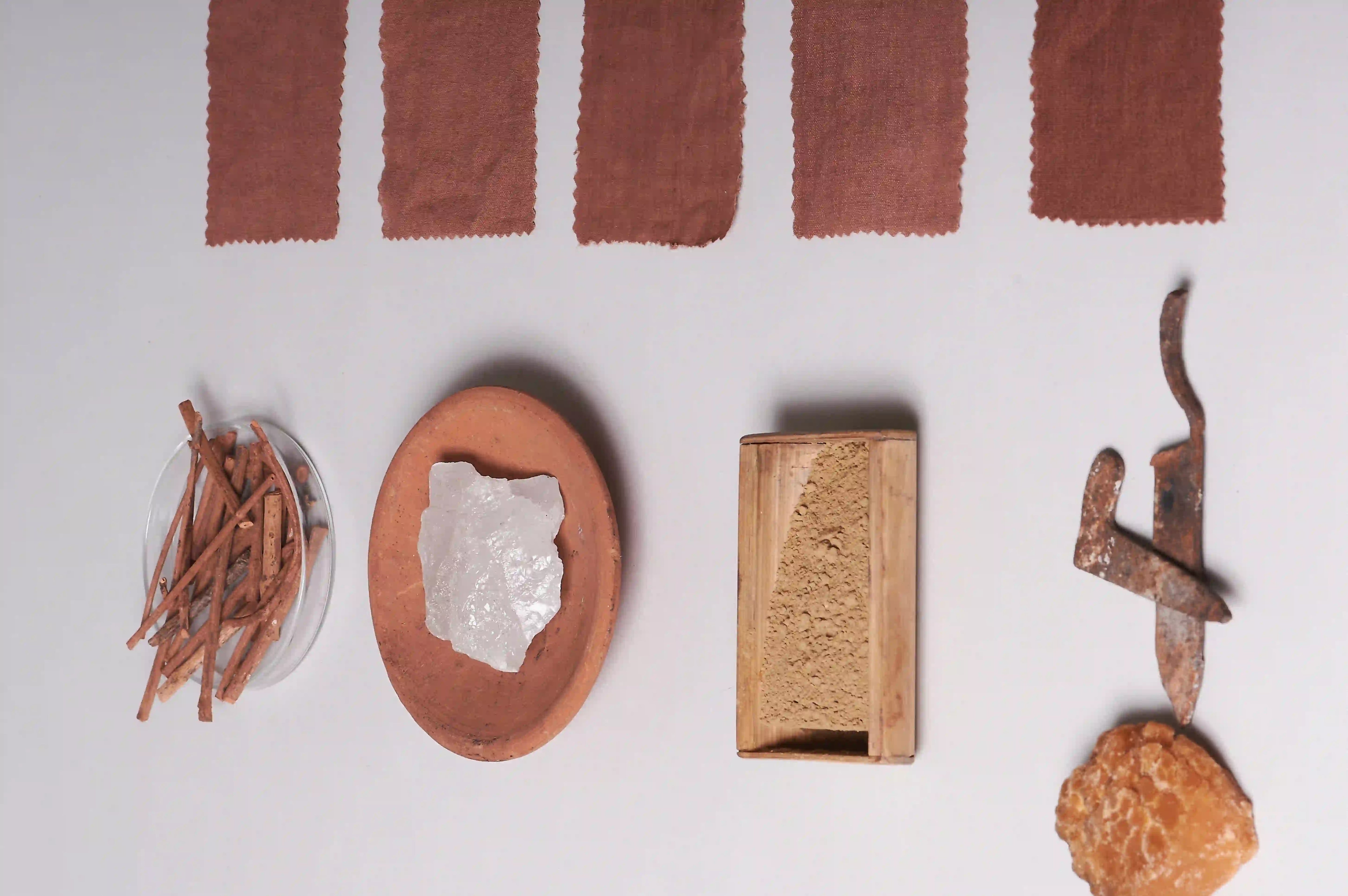 Collection of natural items including stones, herbs, and a wooden box on a grey background