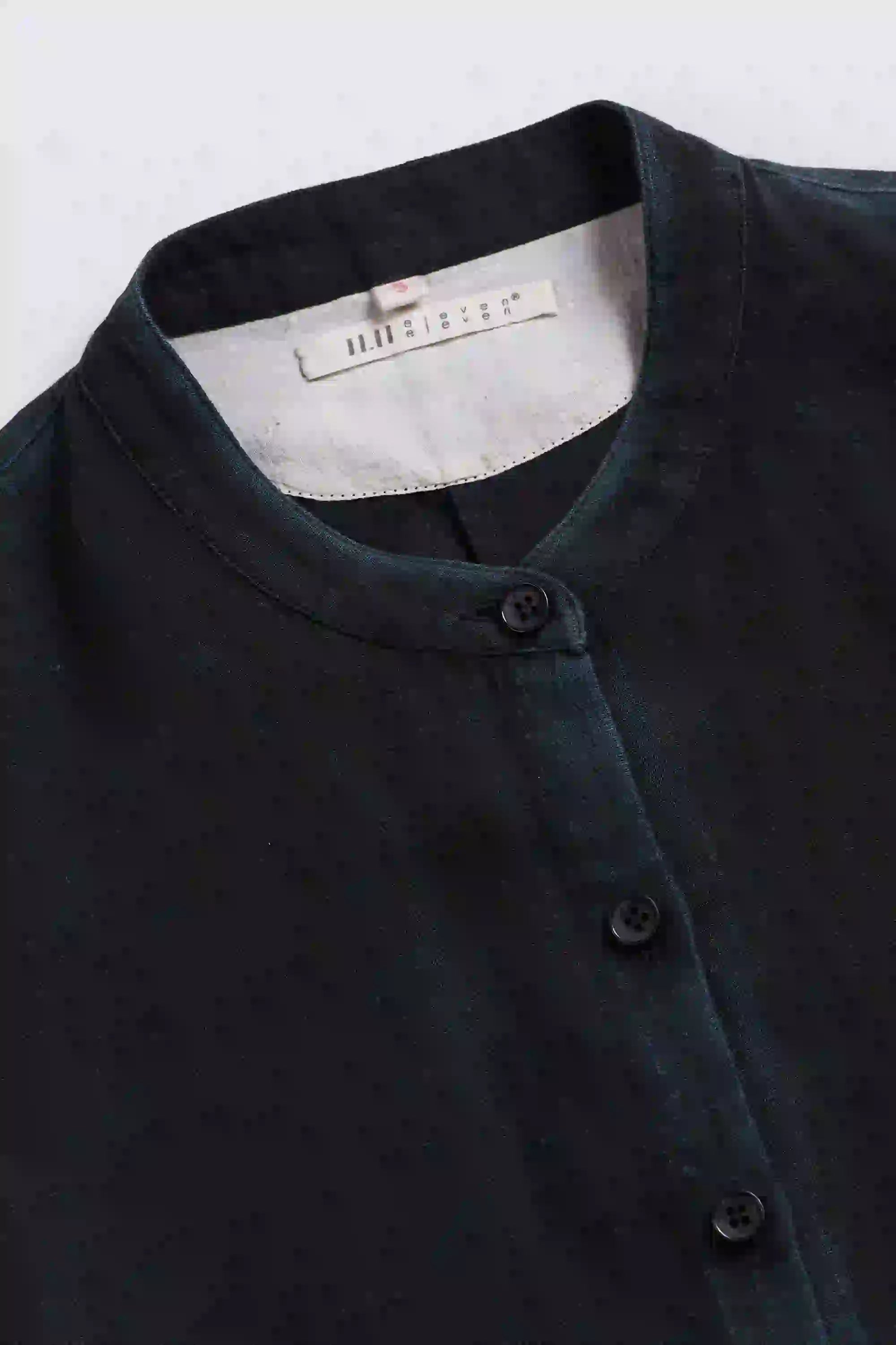 Neck close-up with a band collar and buttons on a grey background