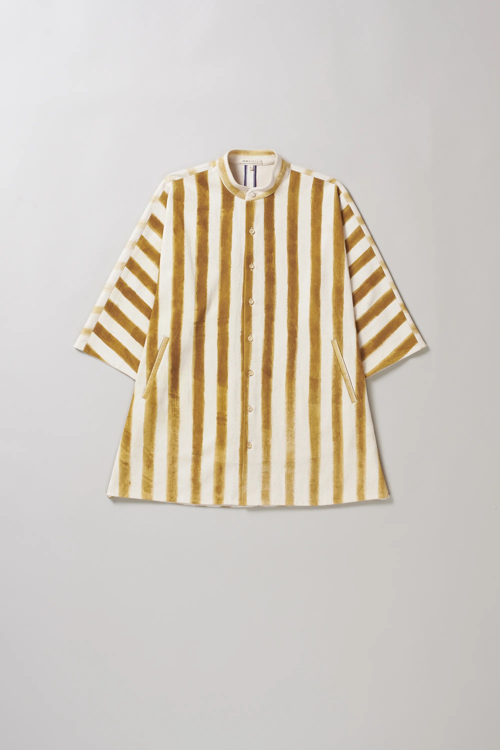 Striped shirt with yellow and white pattern on a light grey background