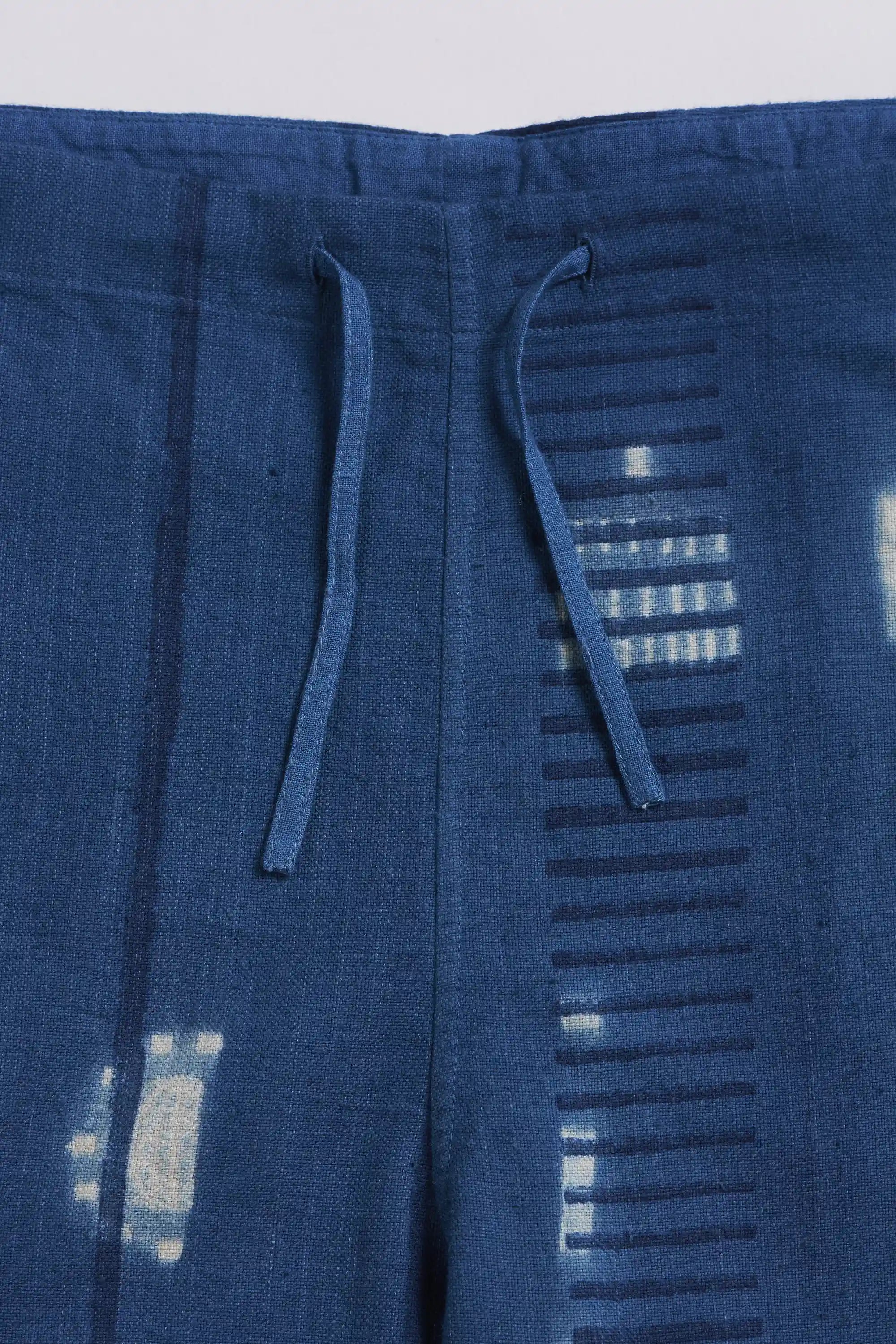 Blue pants with drawstring on a light grey background