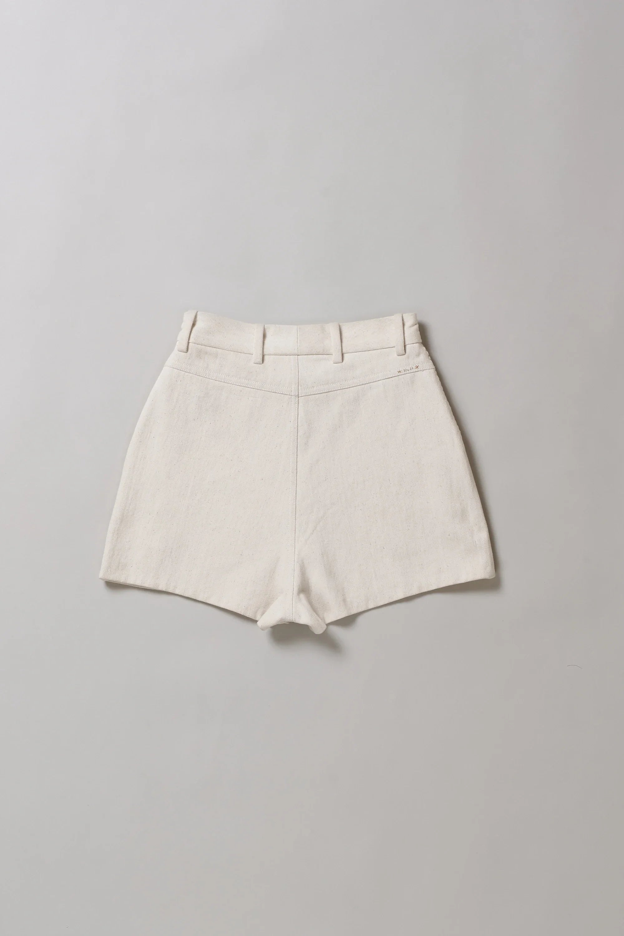 Back image of ecru shorts on a grey background
