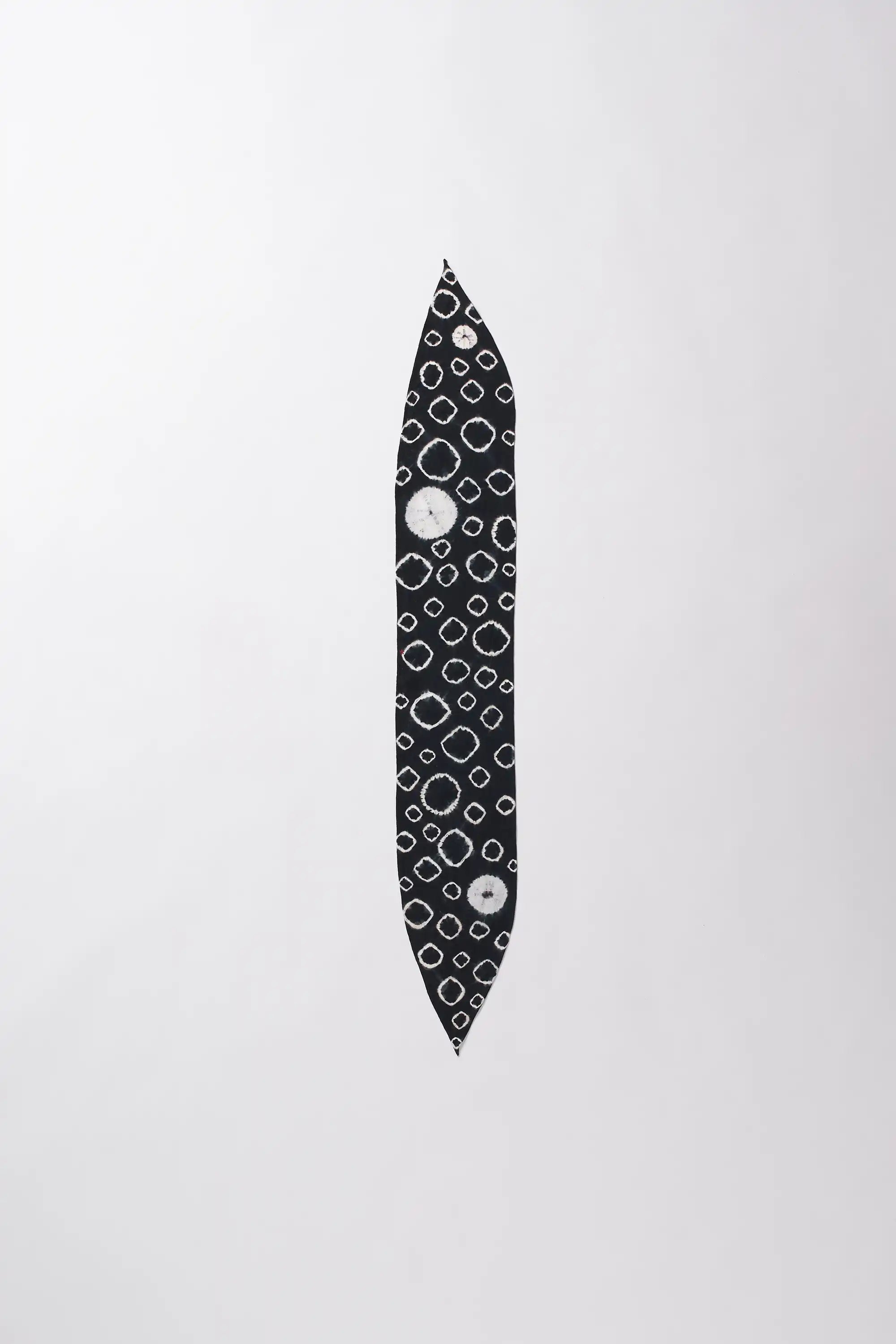 Black and white patterned object on a light grey background