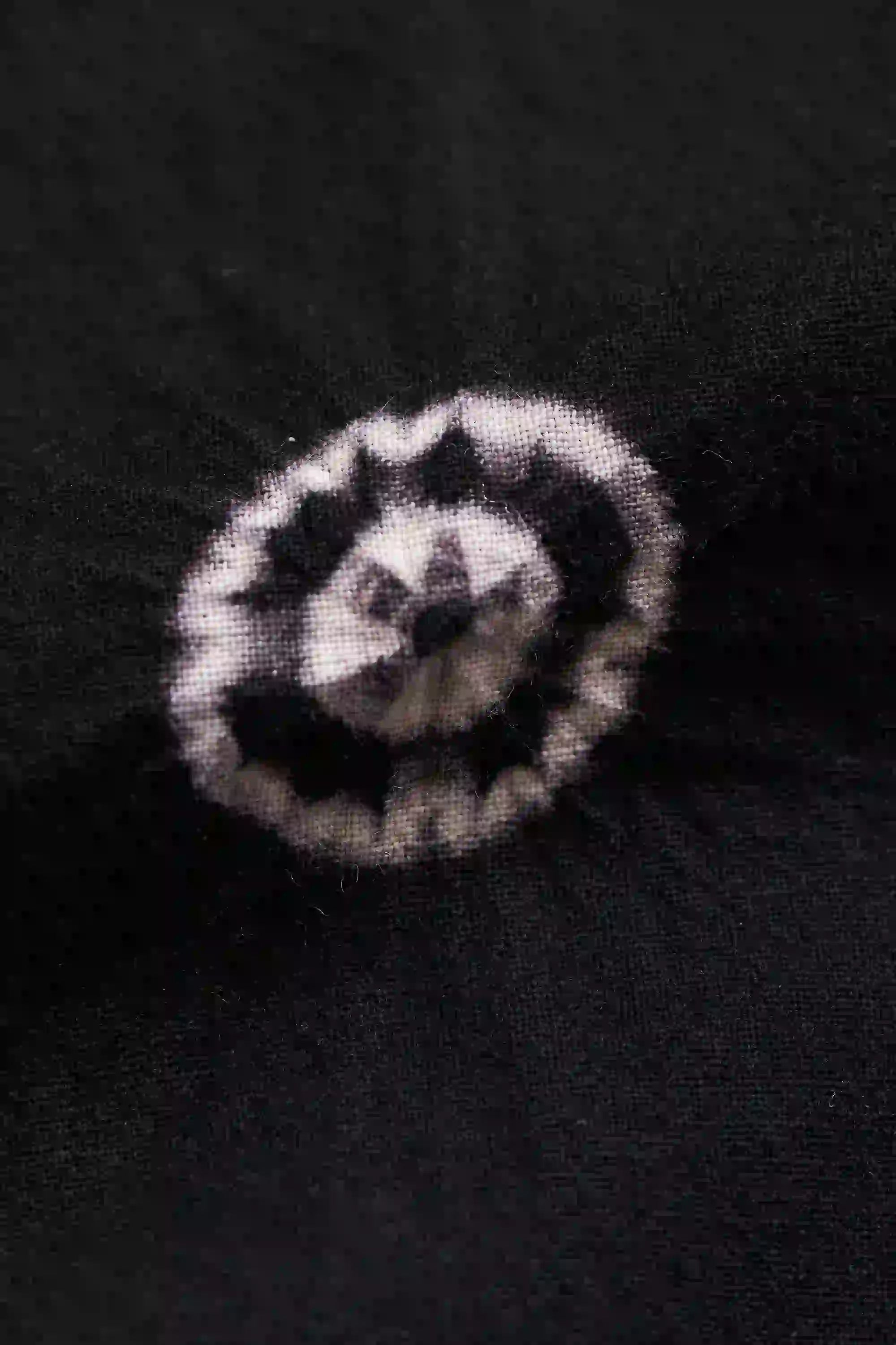Black and white patterned object on a dark background