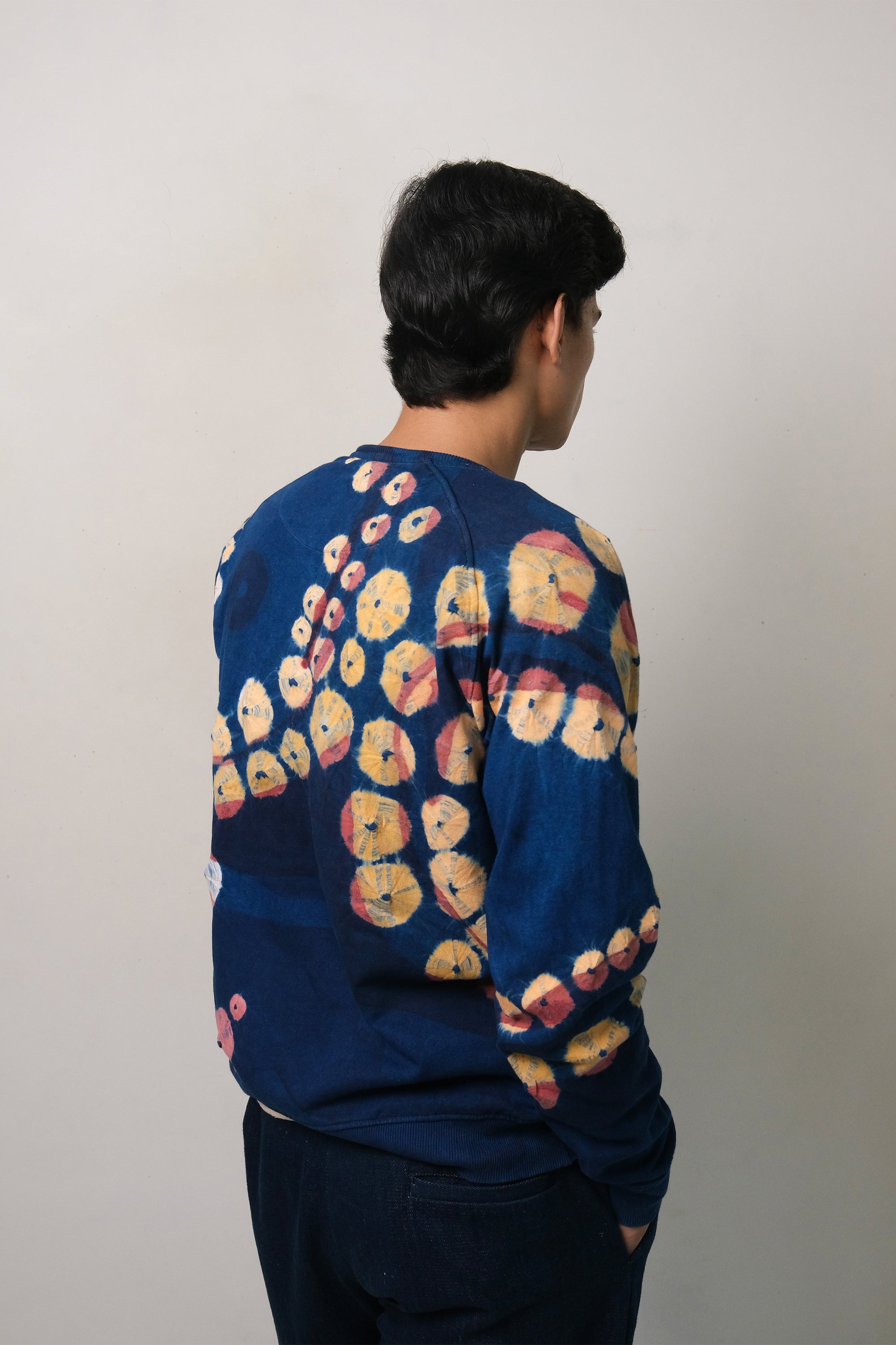 Back shot a man wearing of medium indigo handpaint bandhani sweatshirt