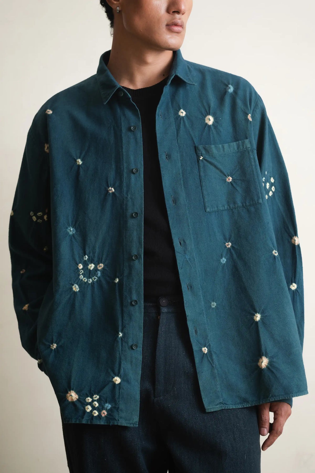 Bottle green shirt with bandhani and buttons worn by a person on a light grey background