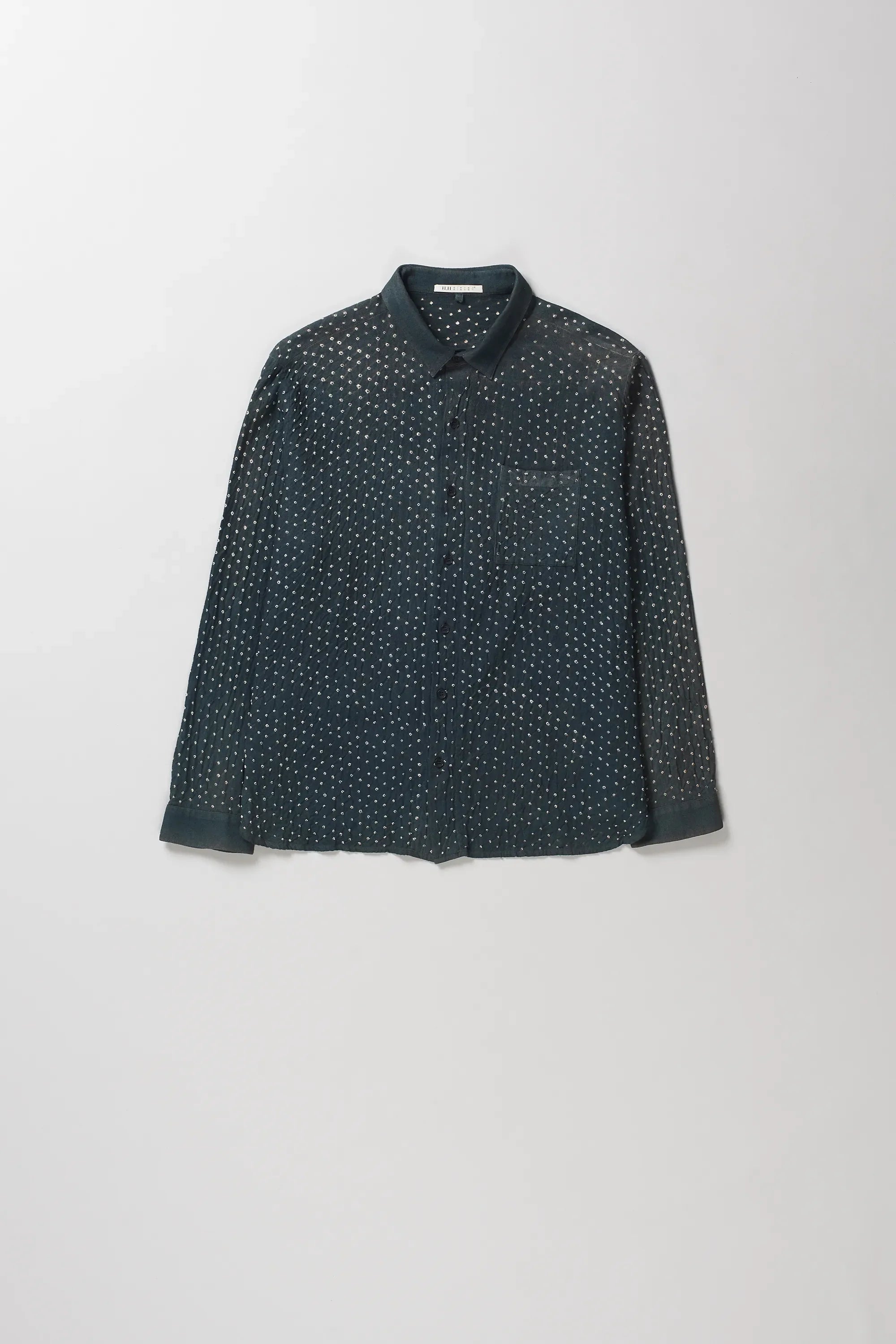 A midnight indigo long-sleeve button-up shirt with a dense white micro-dot bandhani pattern, displayed flat against a light gray background.