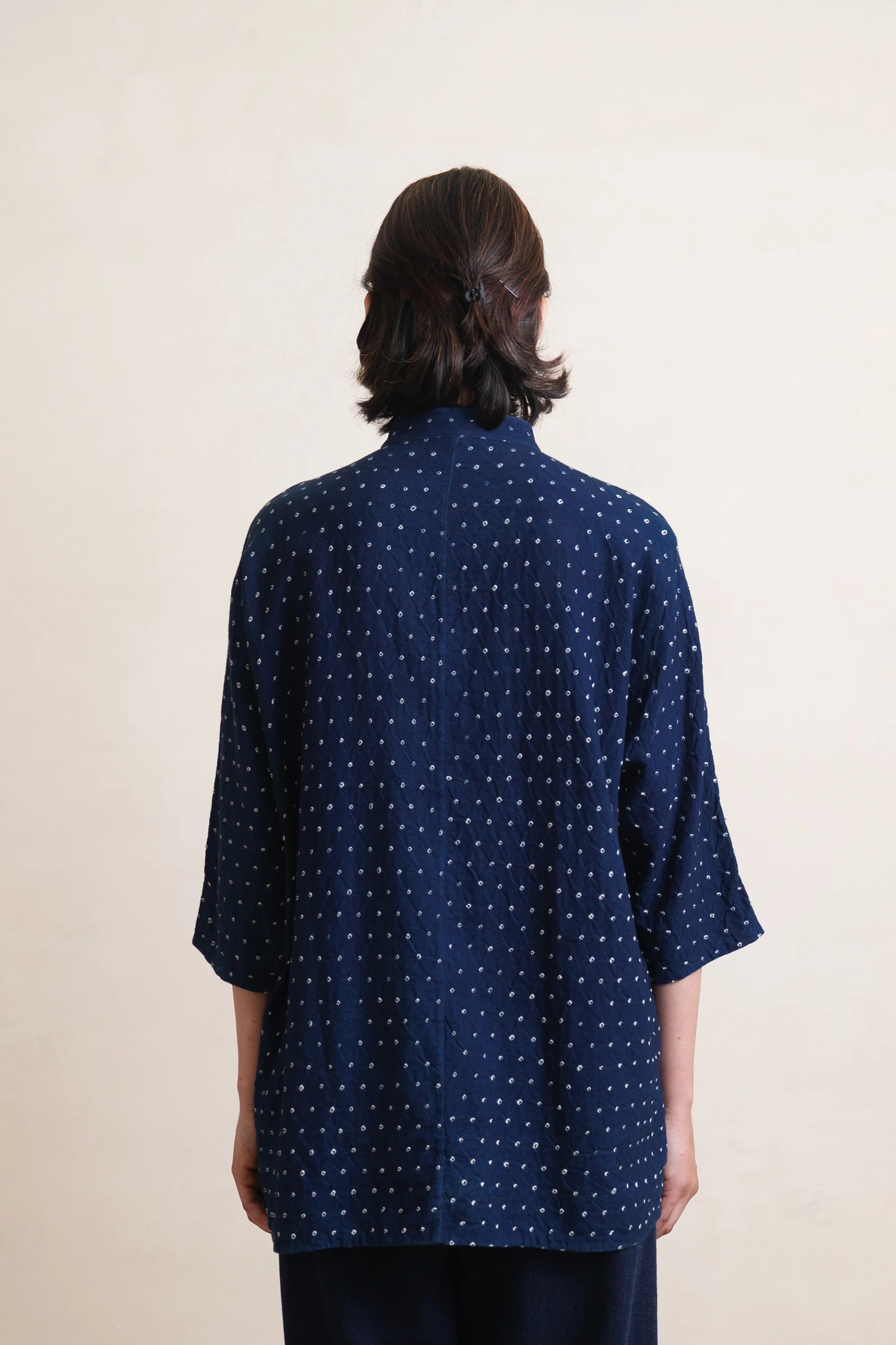 A back shot of a woman wearing a indigo bandhani shirt