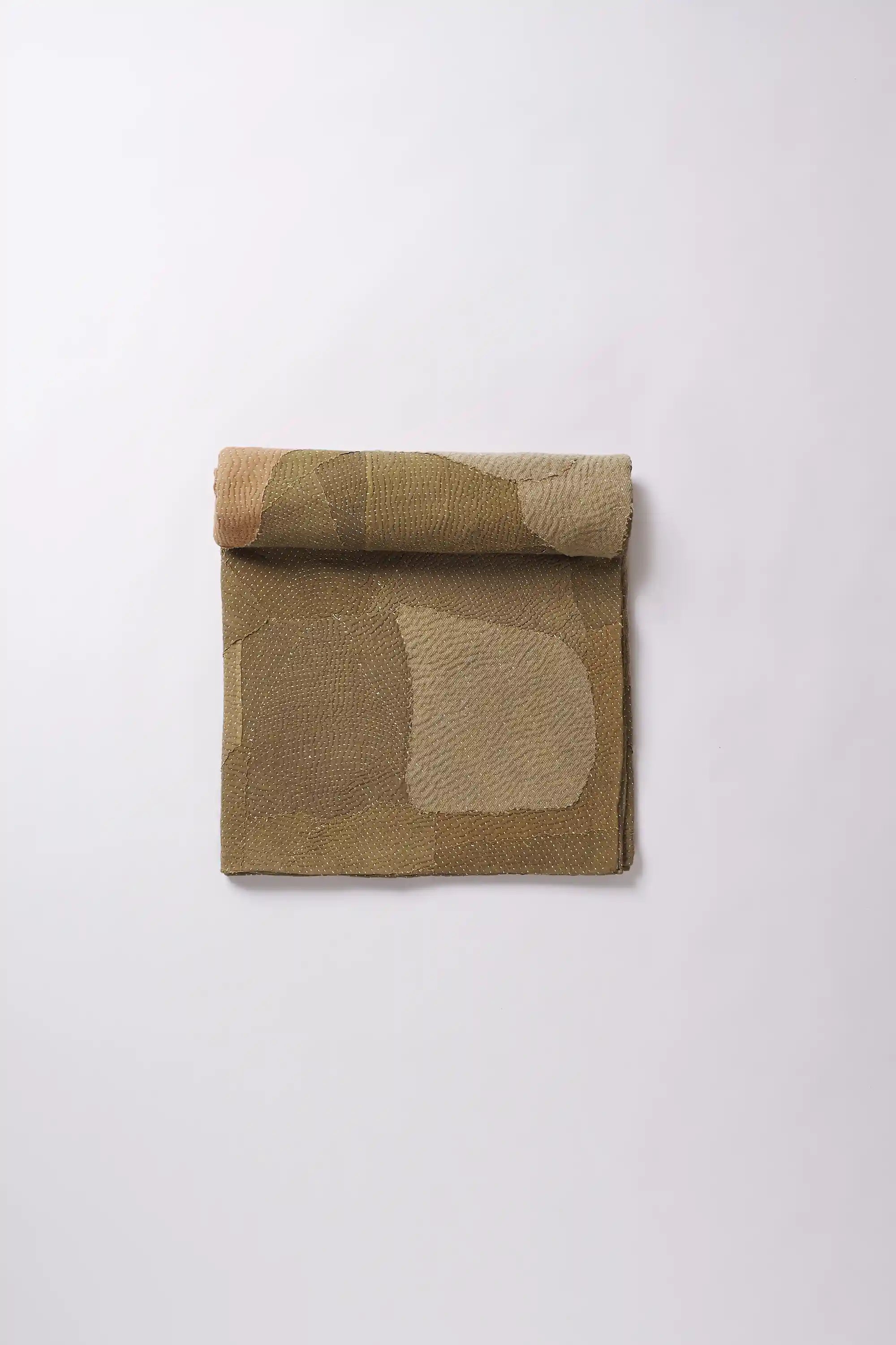 A brick red quilt roll on a light grey background
