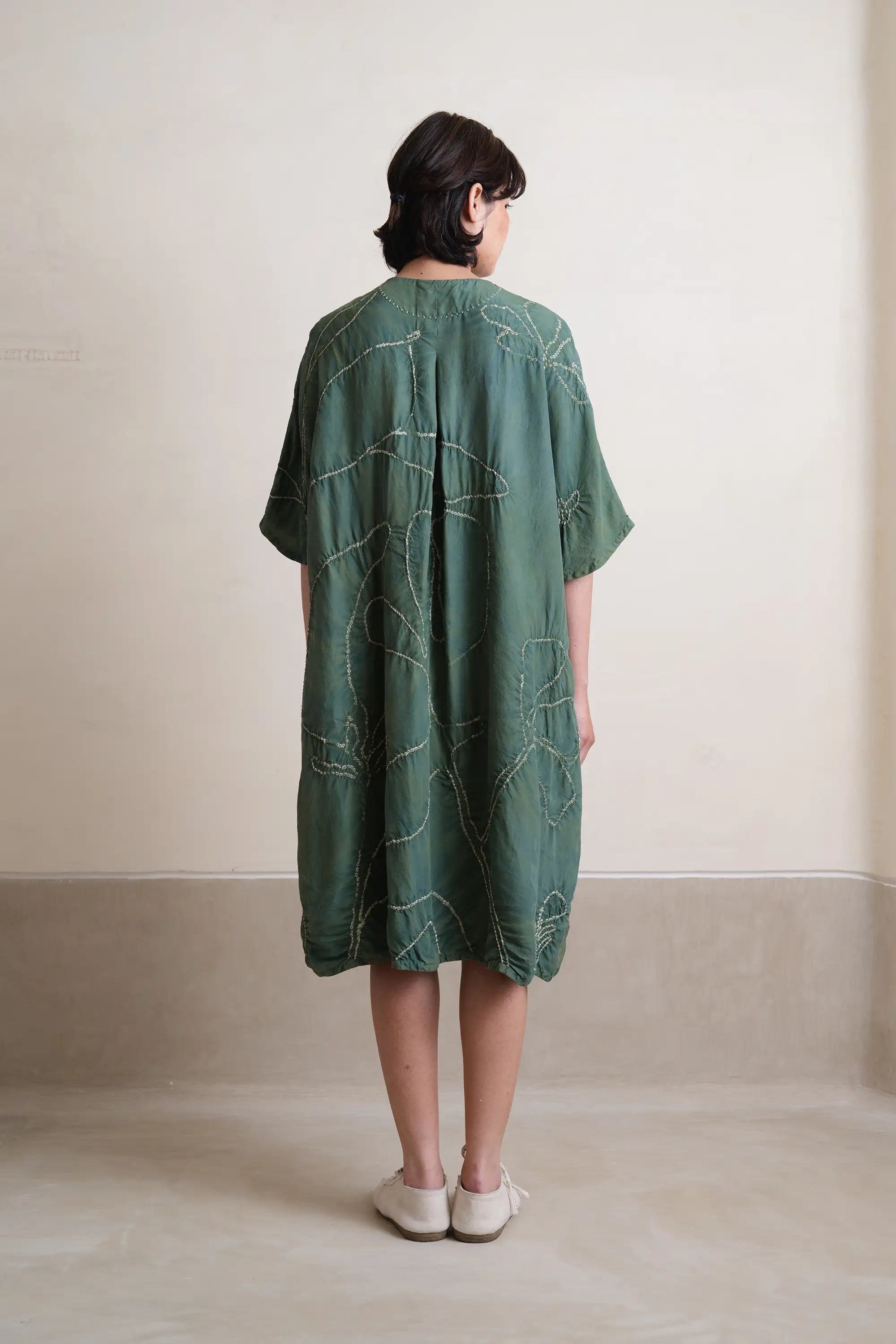 A back shot of woman wearing olive green dress