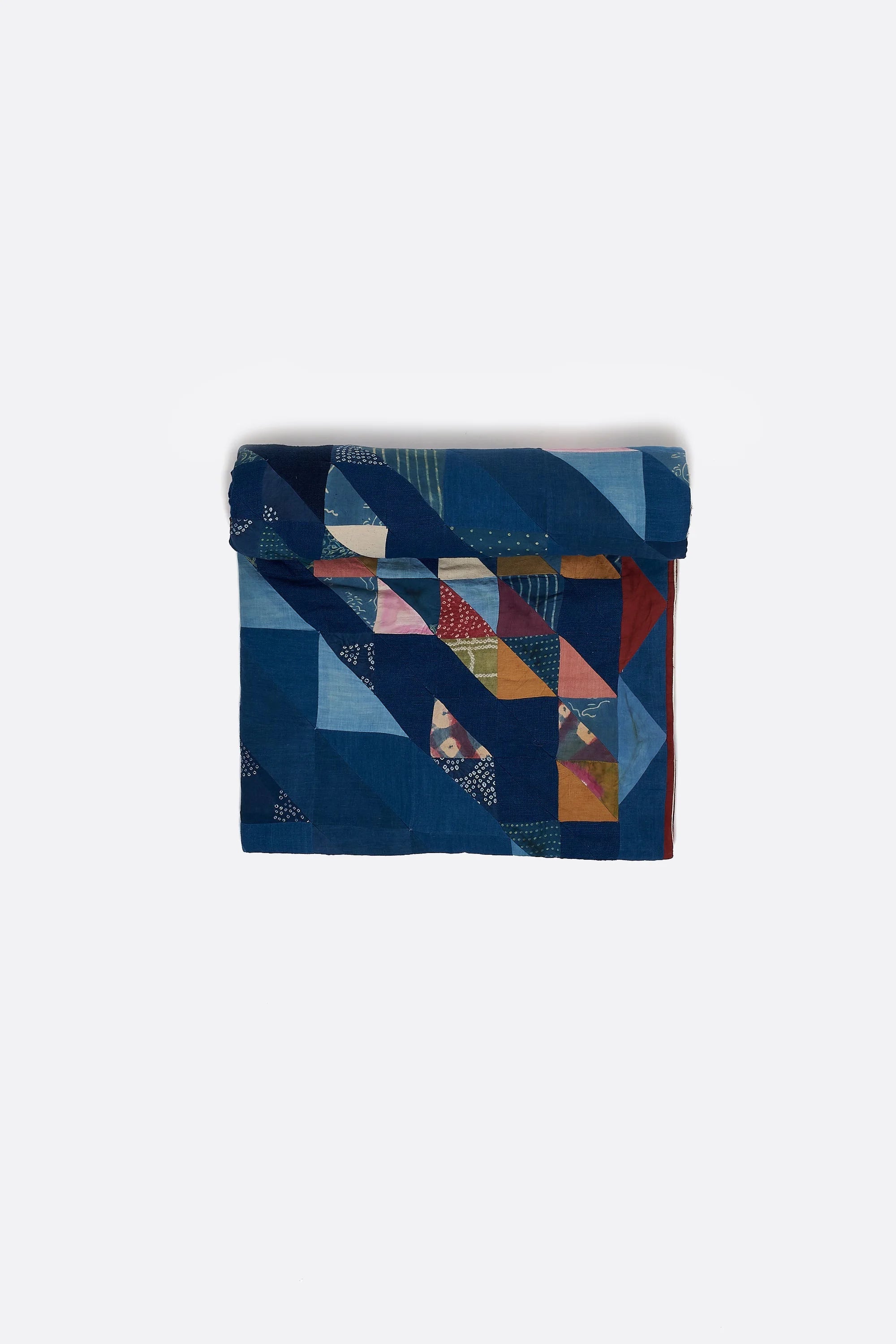Colorful patterned quilt roll on a white background